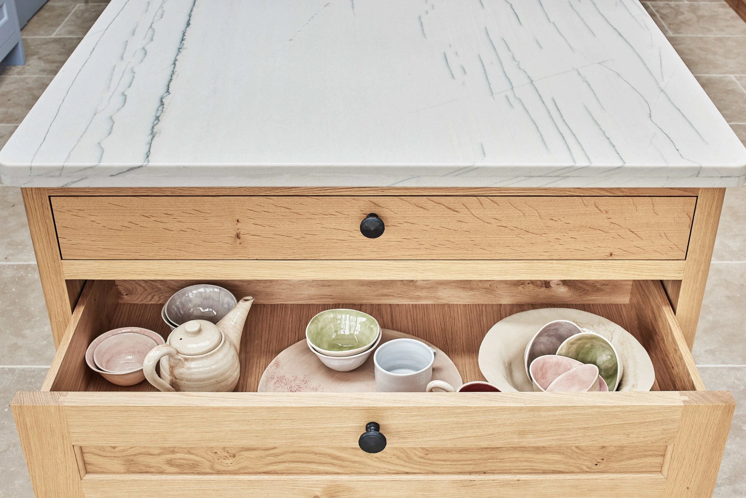 destail of oak deep drawers in bespoke kitchen island with quartzite surface