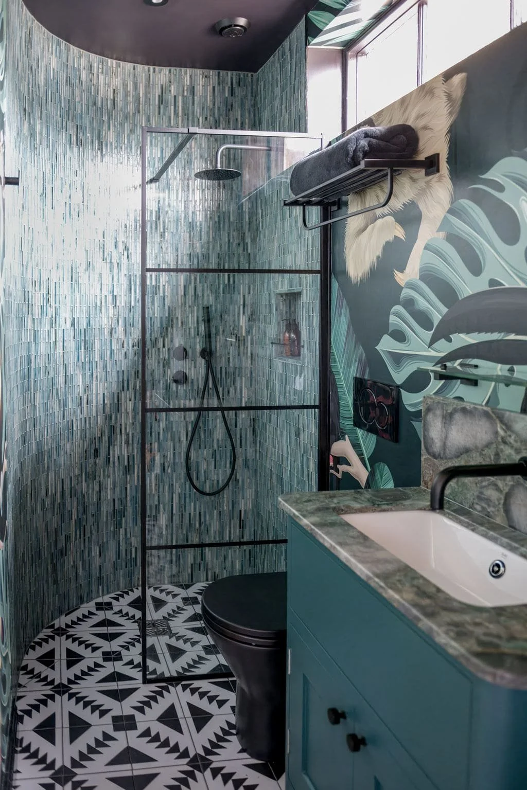 Colourful family bathroom in Surrey with handmade cabinetry, black WC and Fired Earth tiles.