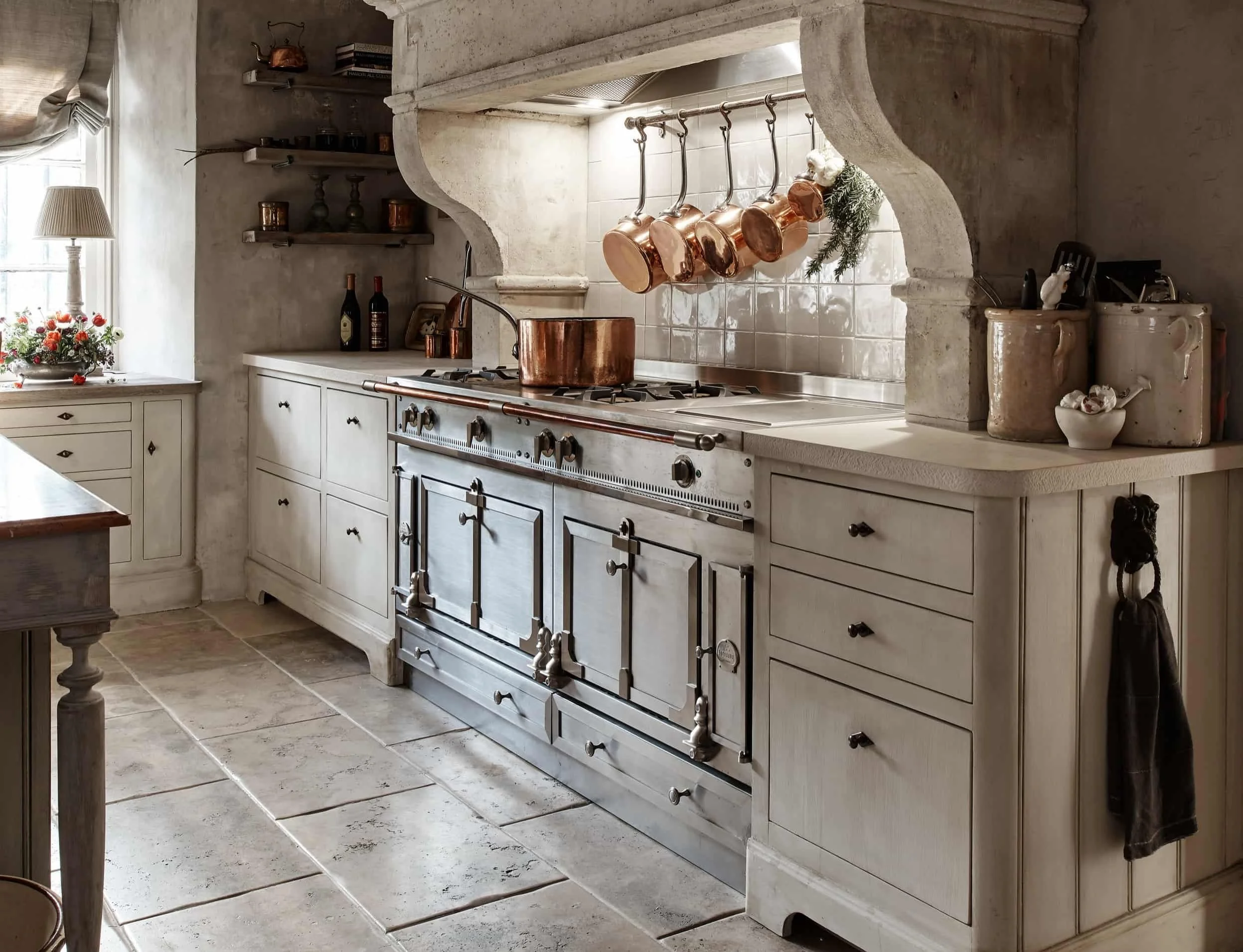 Handmade 18th-century style kitchen in Surrey with La Cornue cooker and copper pans.