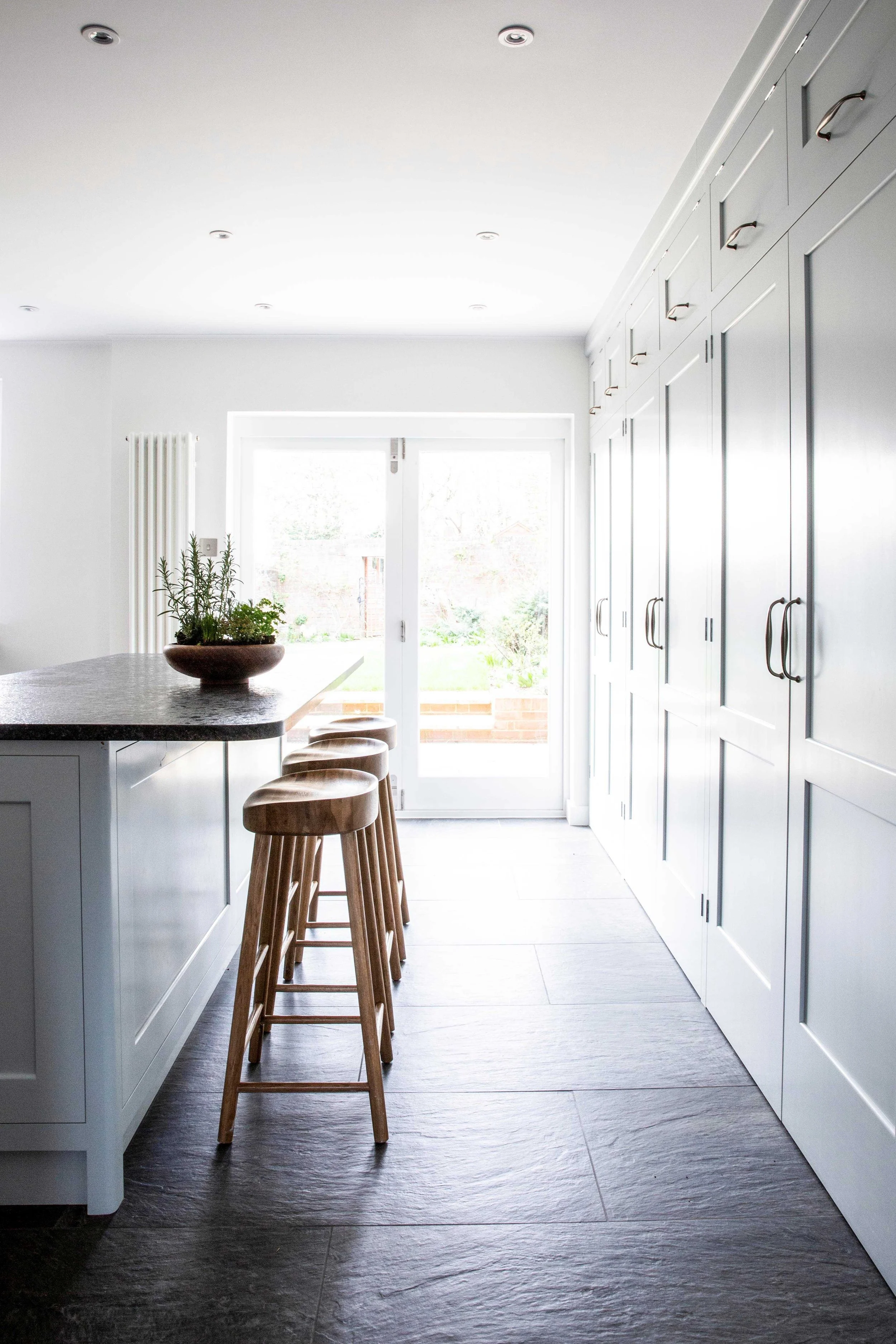 Handmade kitchen island and bespoke cabinetry with garden doors in Surrey home.