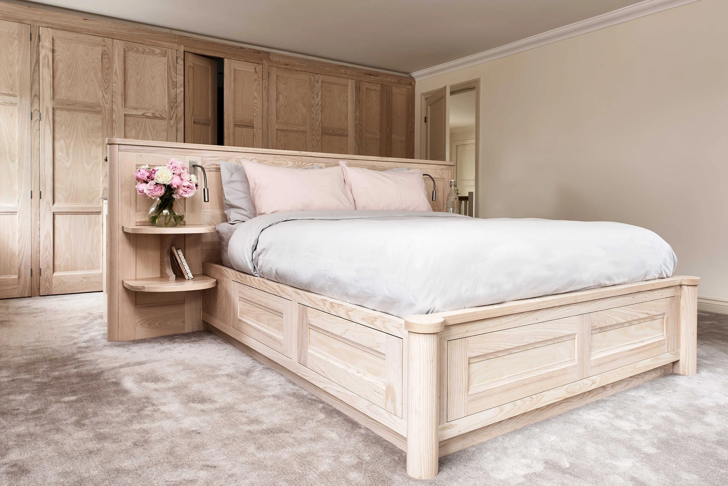 Curved bedroom cabinetry with handcrafted tulip wood wardrobes in bespoke interior design.