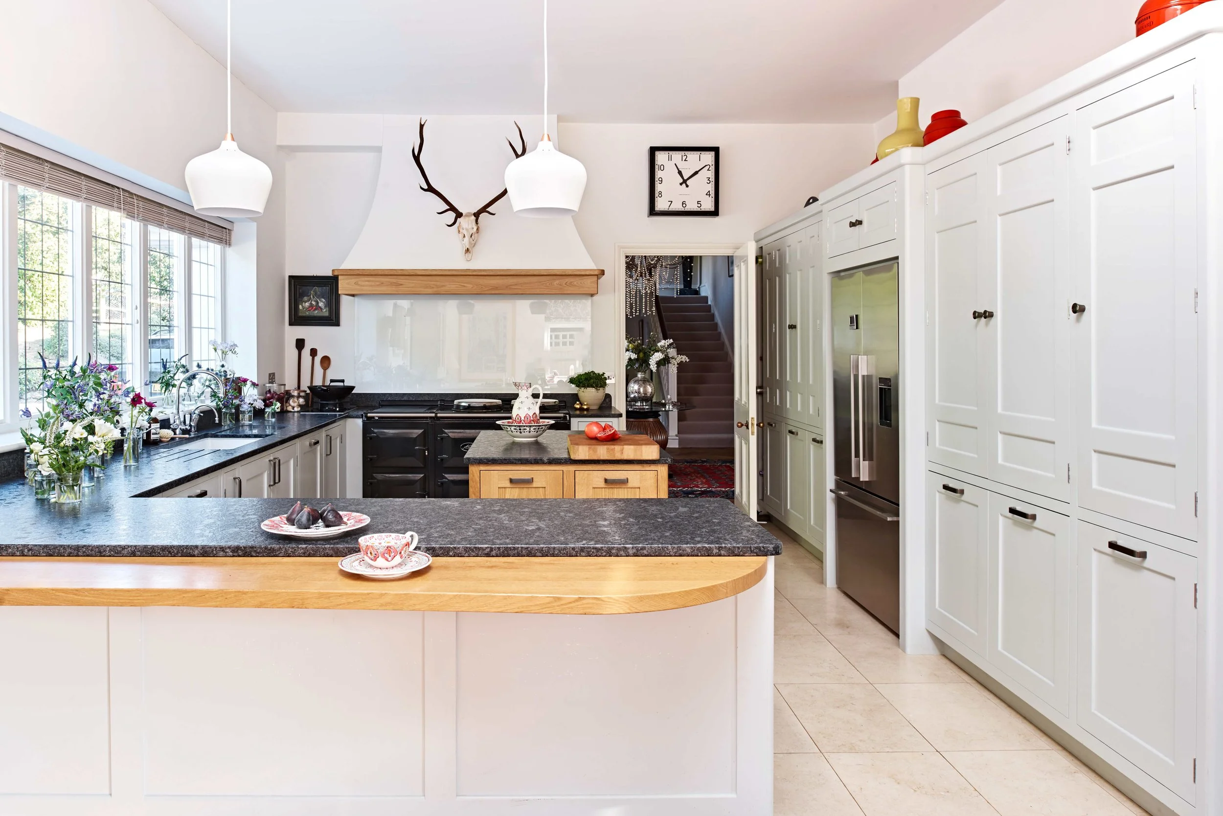 Handmade open-plan Surrey kitchen with bespoke finishes and traditional kitchen clock.