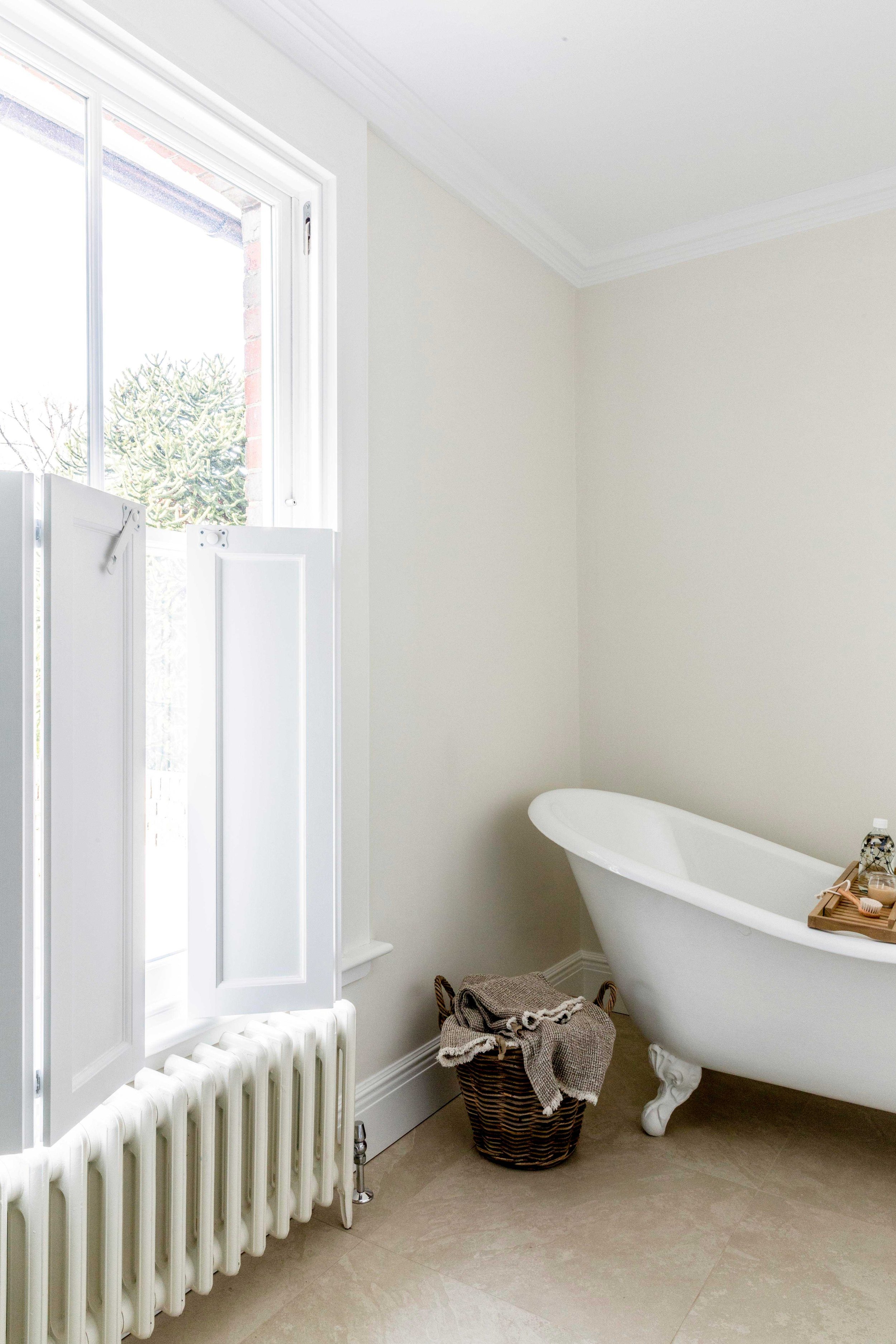 Family bathroom with claw-foot roll-top bath and handmade cabinetry in Surrey Georgian home.