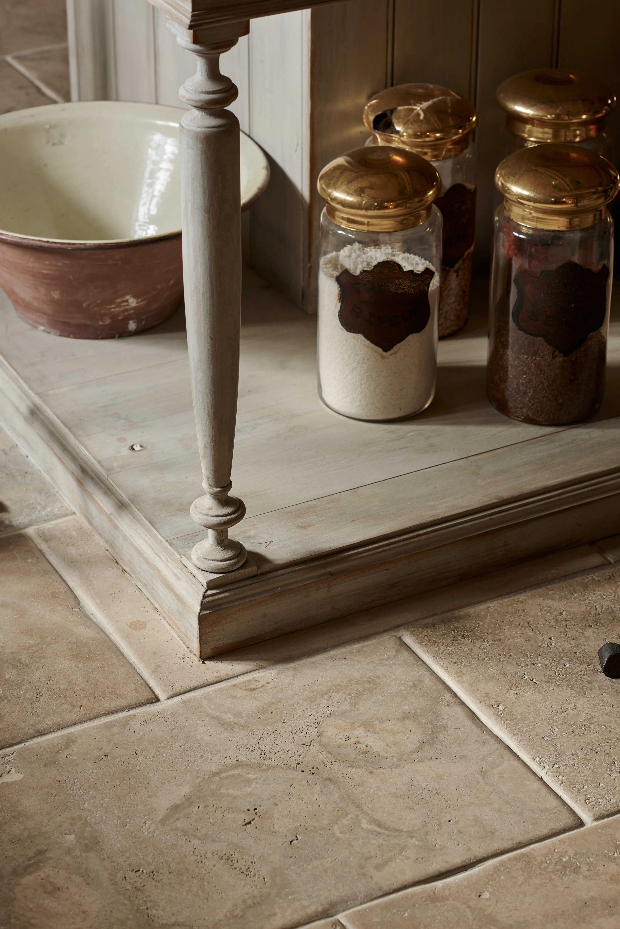 Detail of handmade kitchen island legs with decorative bowls and jars.