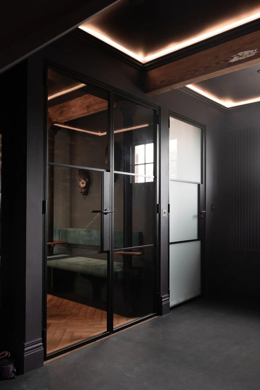 Large Crittall glass doors dividing Guildford games room and home gym, with bespoke joinery.