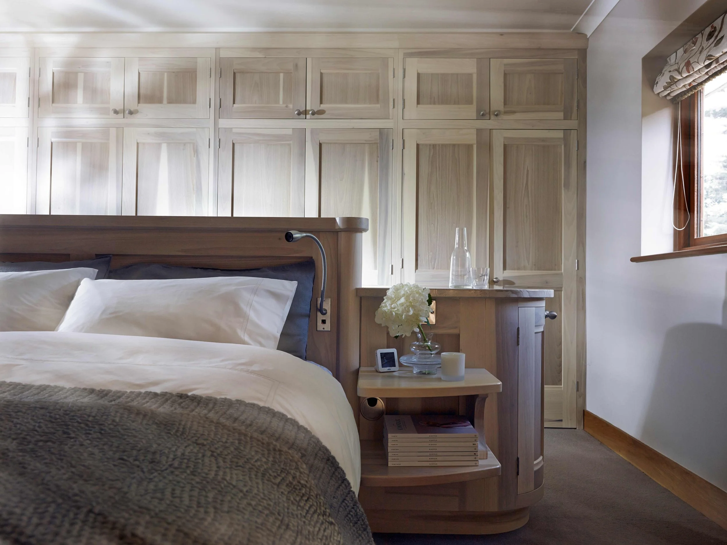 Tulip wood bedroom cabinetry with custom-made island bed in handcrafted interior scheme.