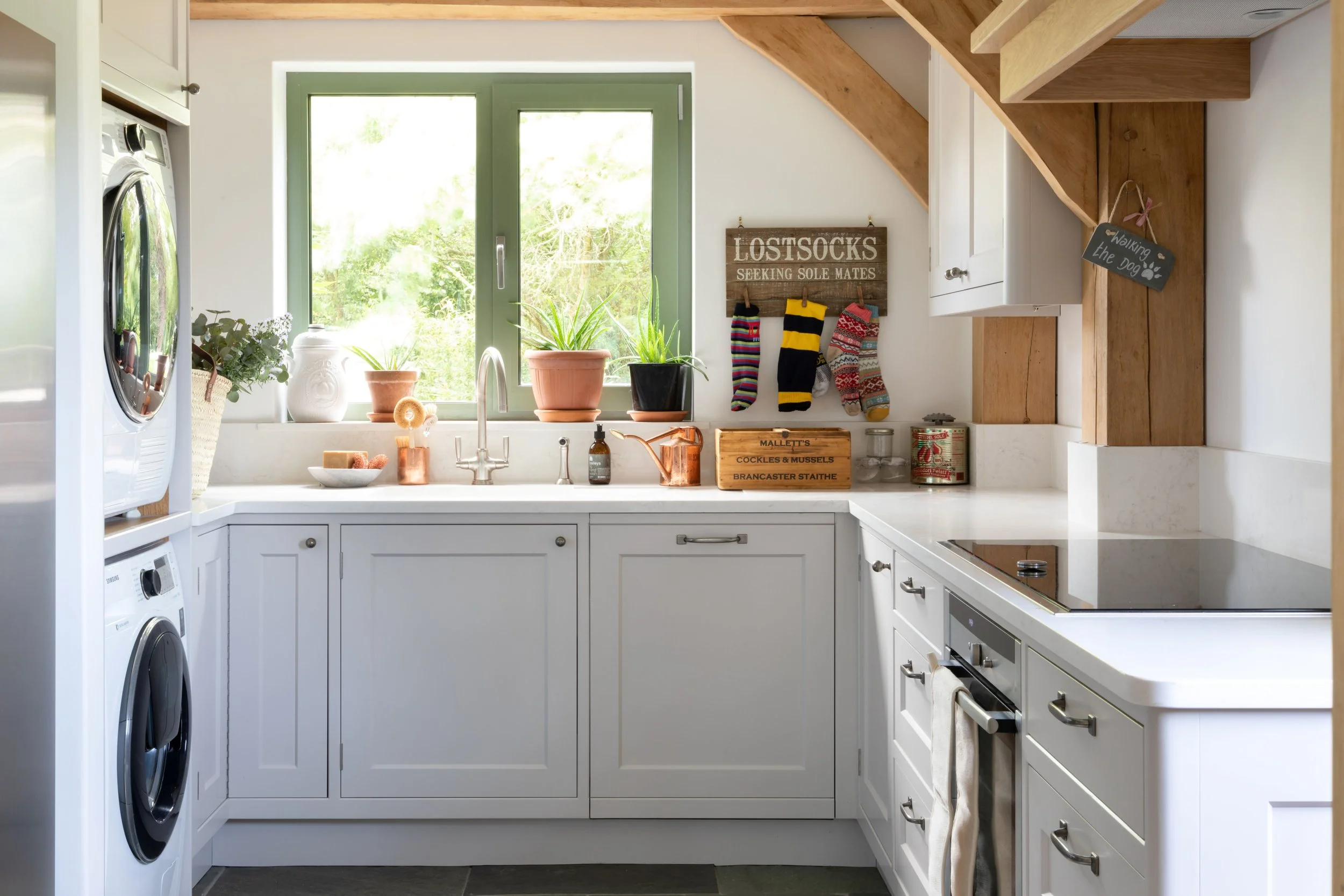 Practical ancillary handmade kitchen in Surrey with copper accessories and fitted appliances.
