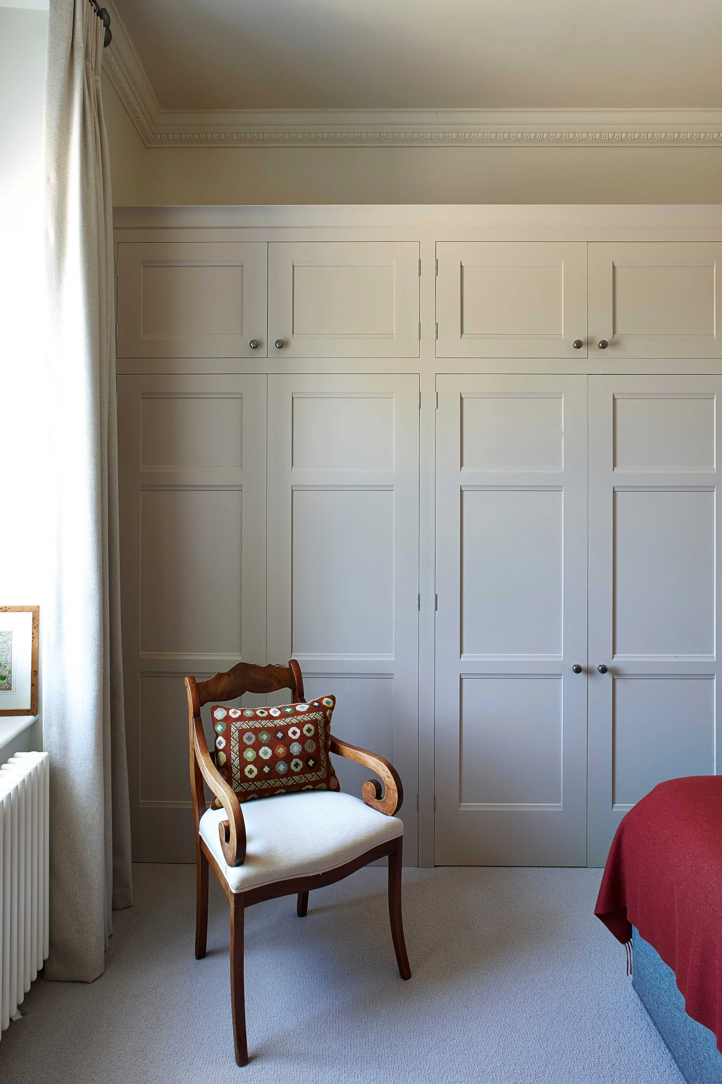 Handmade grey-painted bespoke linen cupboard in Surrey home.