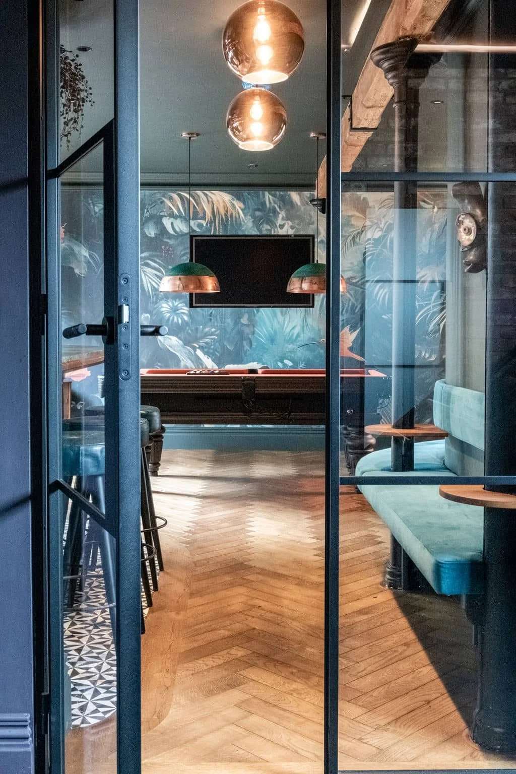 Handmade bespoke bar refurbishment in Surrey with pool table and blue velvet bench seating.