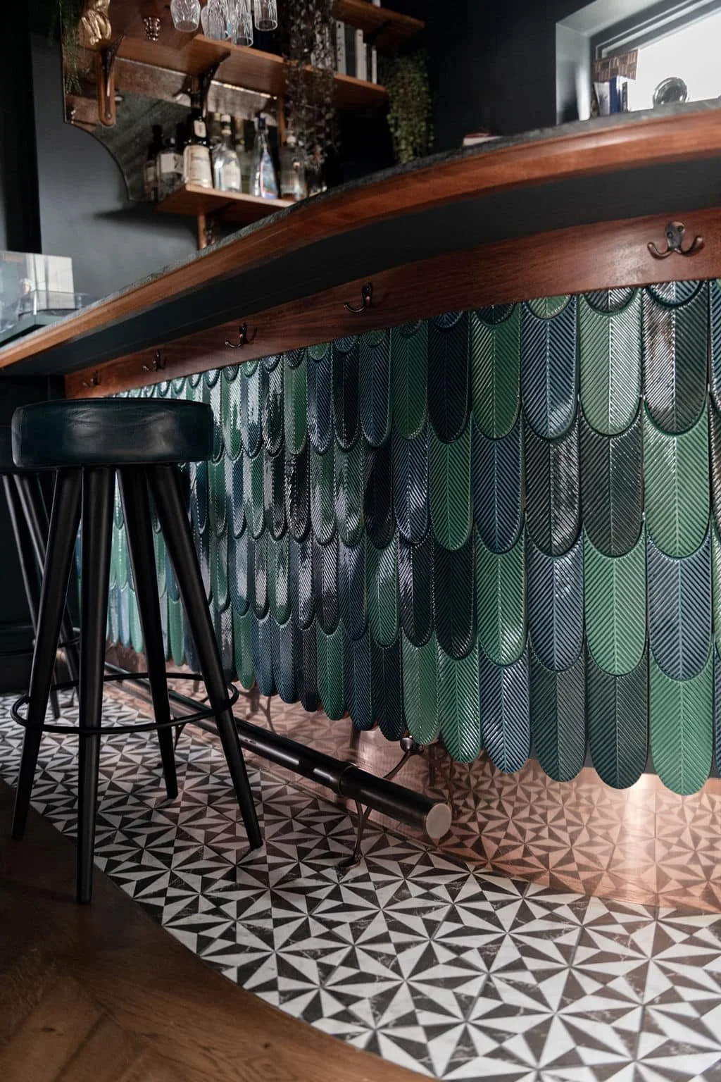 Handmade bespoke bar with curved wooden top, copper trim and Turkish green tiles in Guildford home.