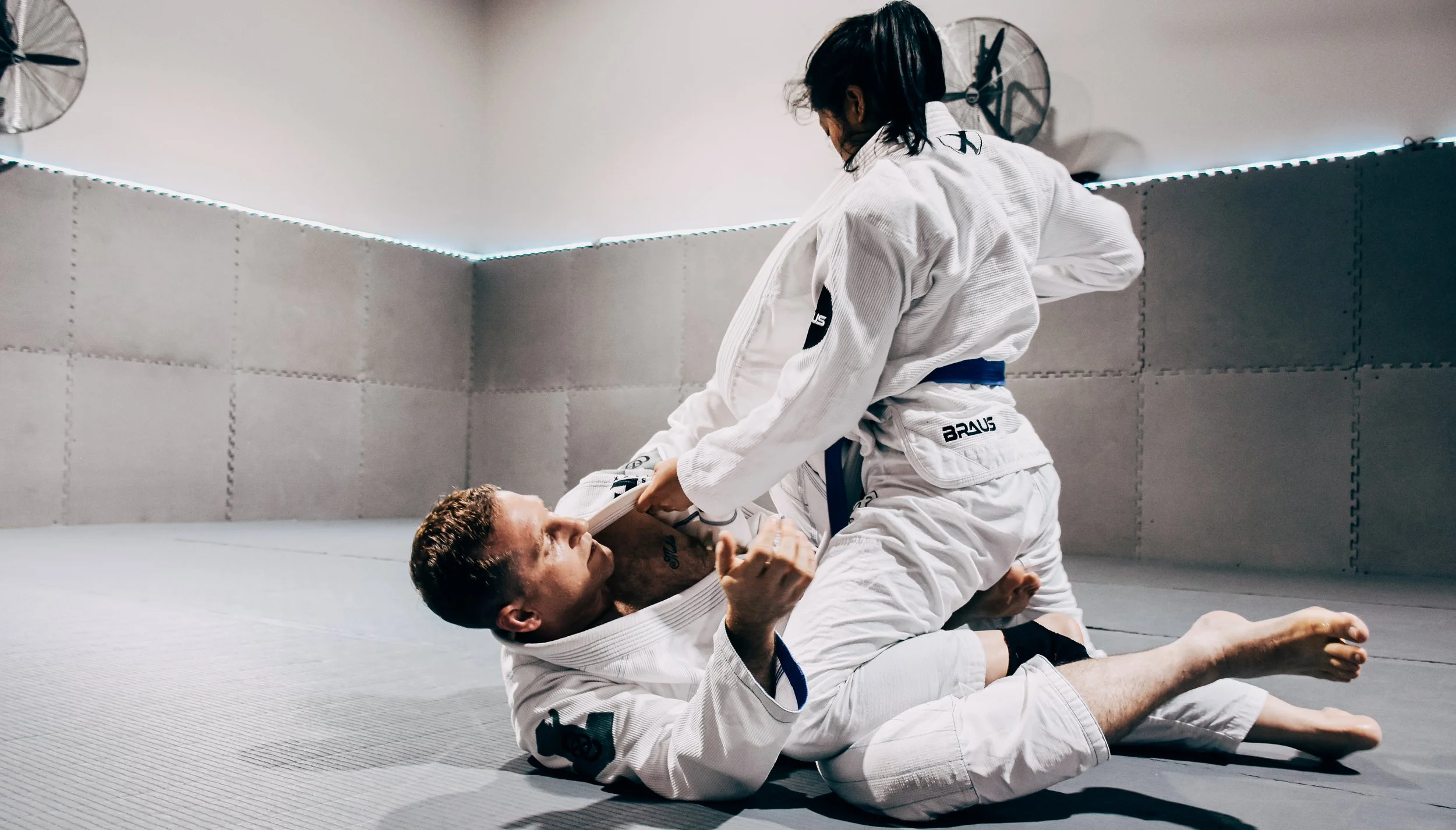 Coach Chris and Sienna rolling during in their pristine white Gis during the 2022 Forge Martial Arts In-house competition