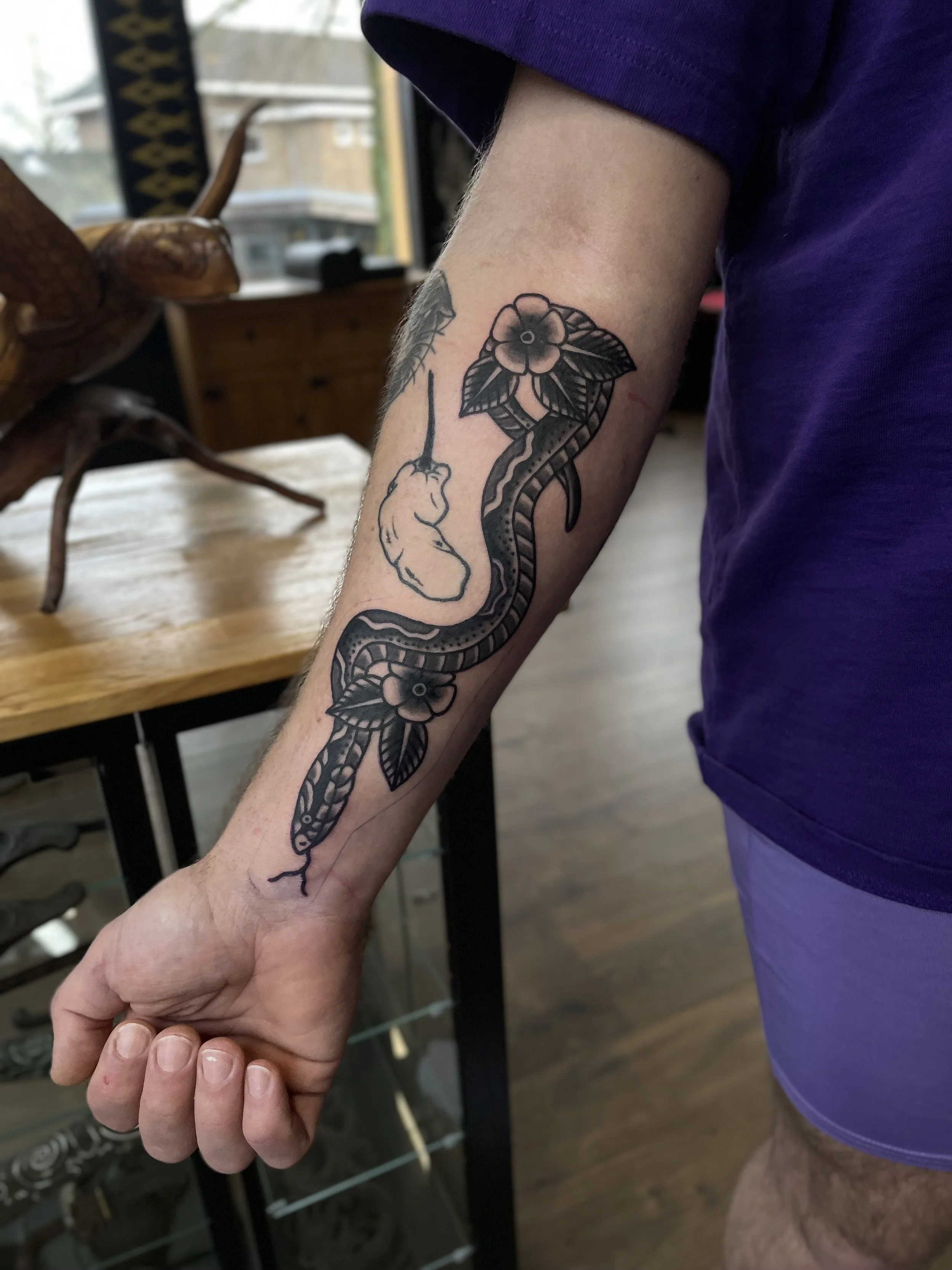 traditional snake and flowers tattoo.jpeg