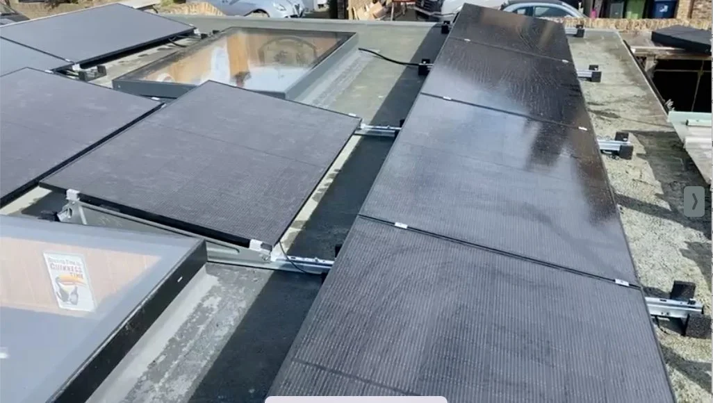 Solar panels installed on a roof with a skylight.
