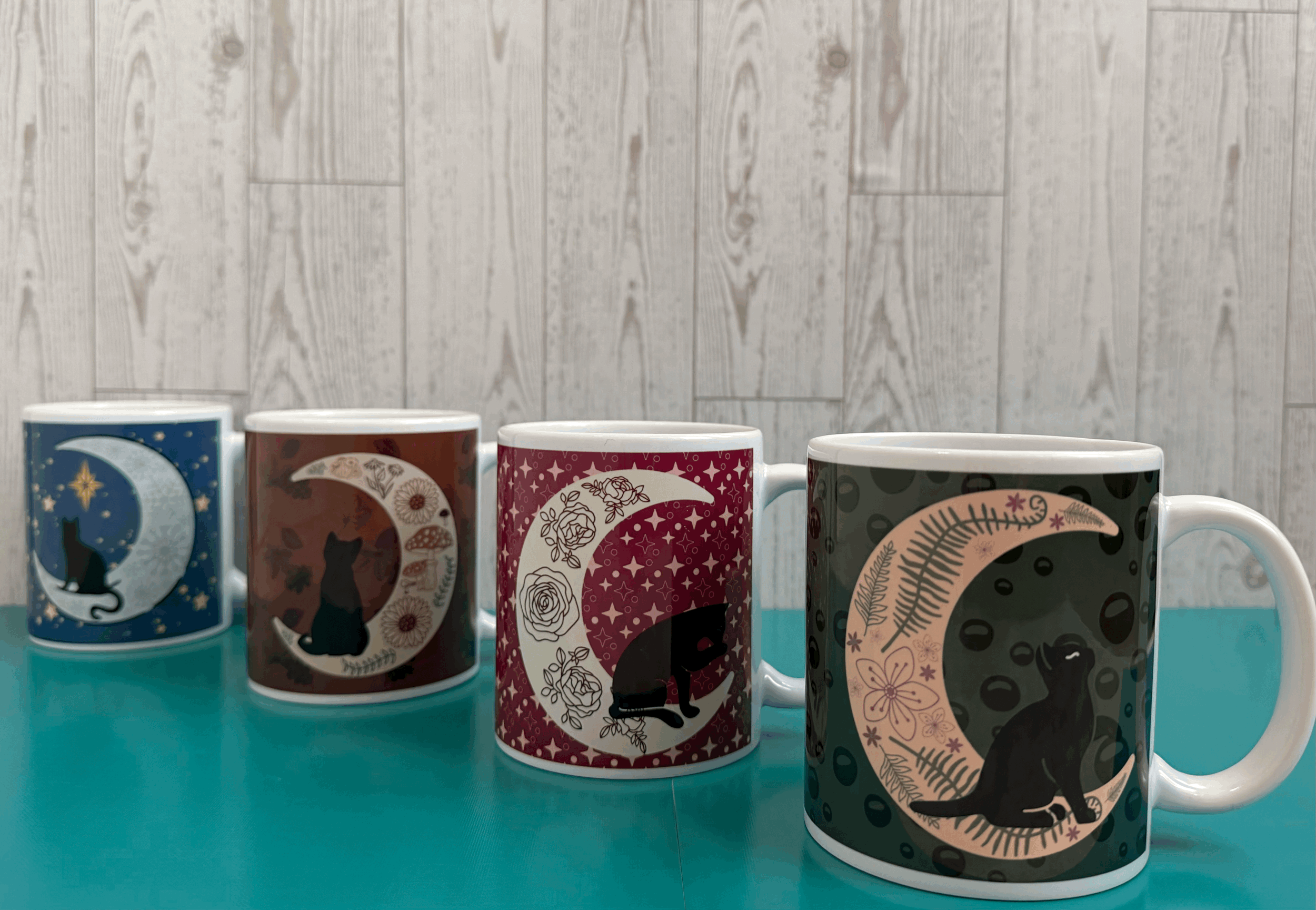 4 seasonally themed coffee mugs, each featuring a different cat and moon design to fit the season.gif