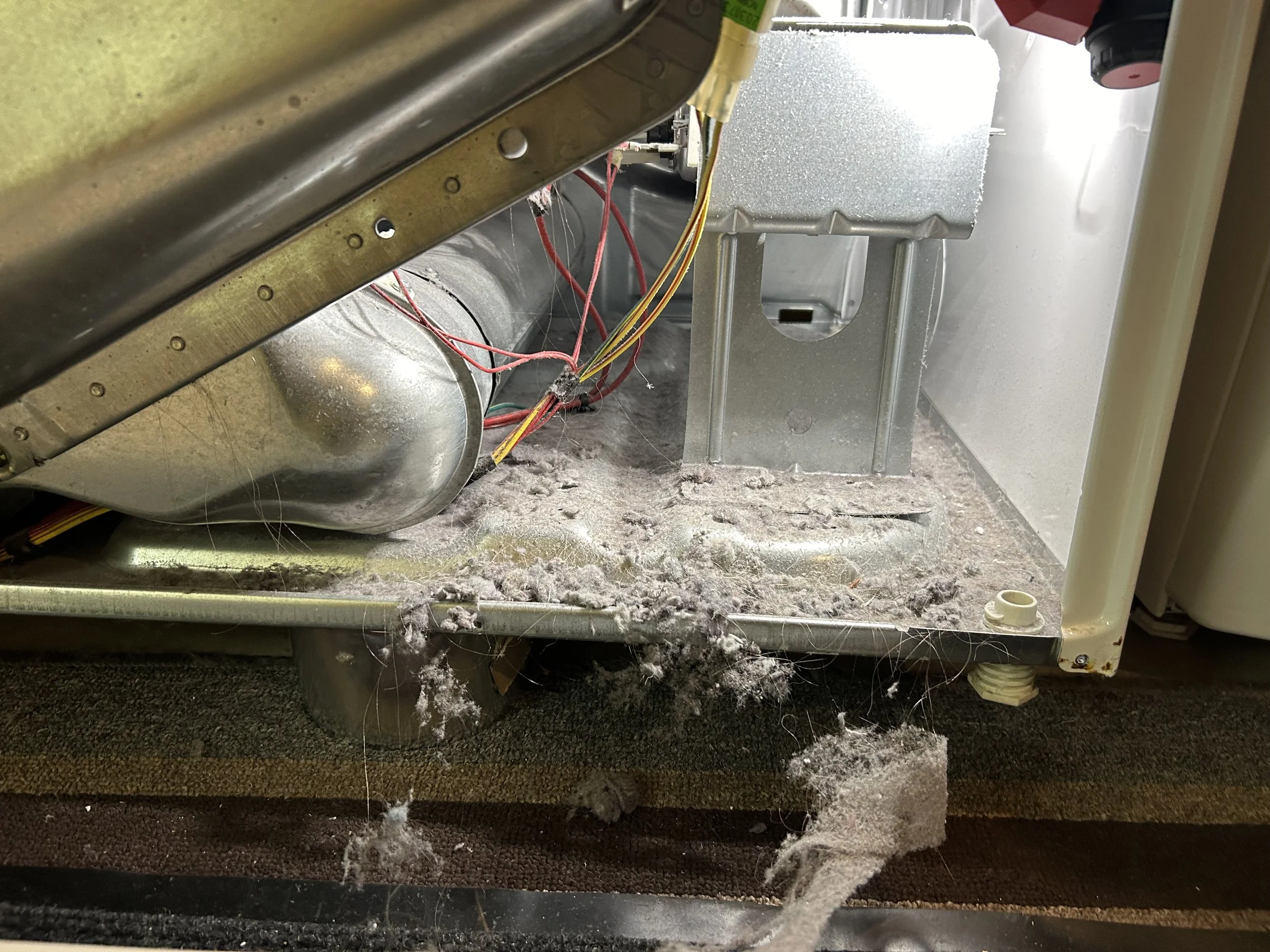 Lint accumulated on inside bottom of dryer by wires