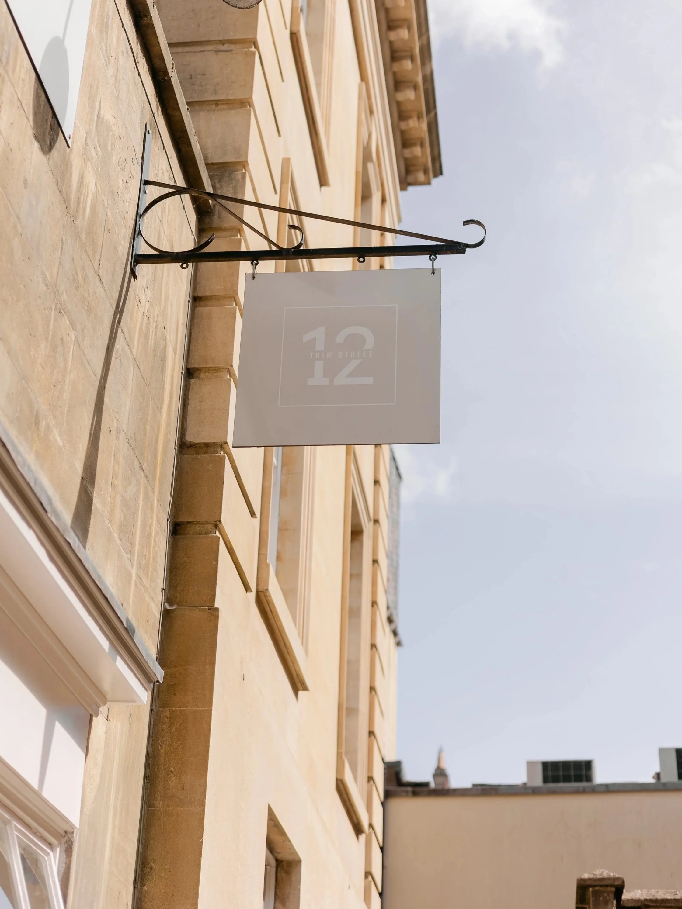 Sign on building in Bath city centre, the sign that reads '12 Trim Street.'
