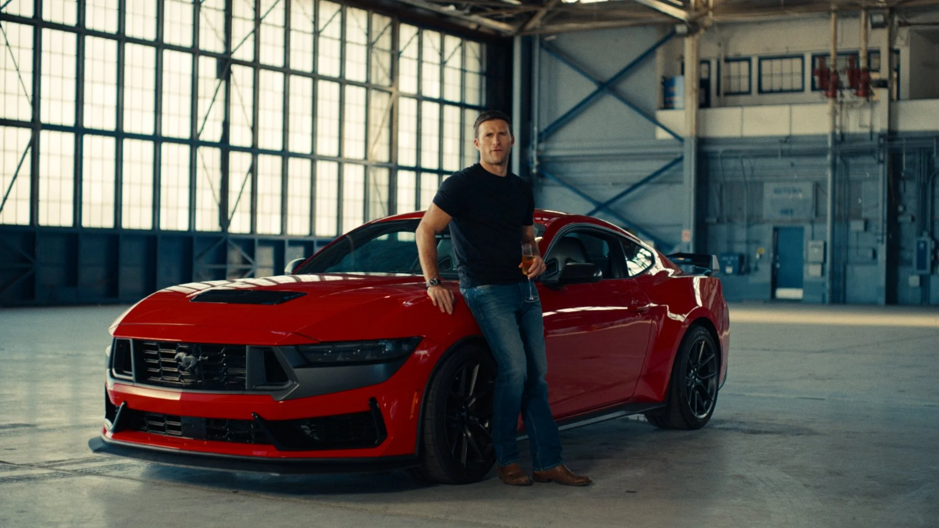 Scott Eastwood standing in front of Mustang Dark Horse