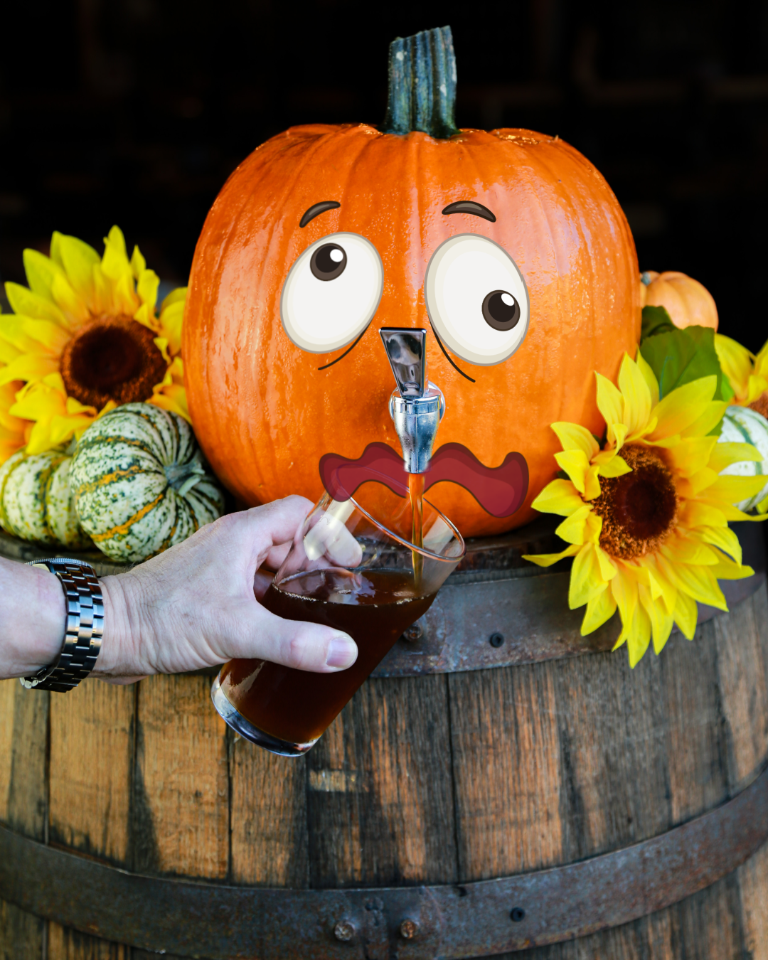 A pumpkin with cartoon eyes and a tap face, dispensing beer into a glass, surrounded by sunflowers and small squashes, on a wooden barrel.