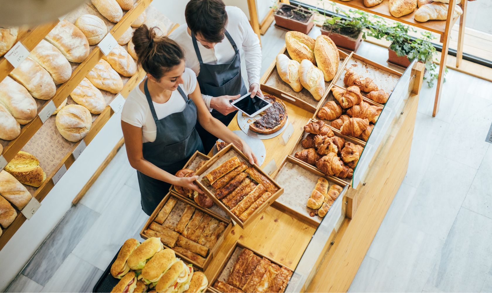 shopping for baked goods in a bakery, browsing bread, croissants, and pastries displayed on wooden shelves and tables. Restaurant consulting for Cleveland & Northeast Ohio. Chef Brad Race helps launch, streamline, and grow restaurants with strategy, 