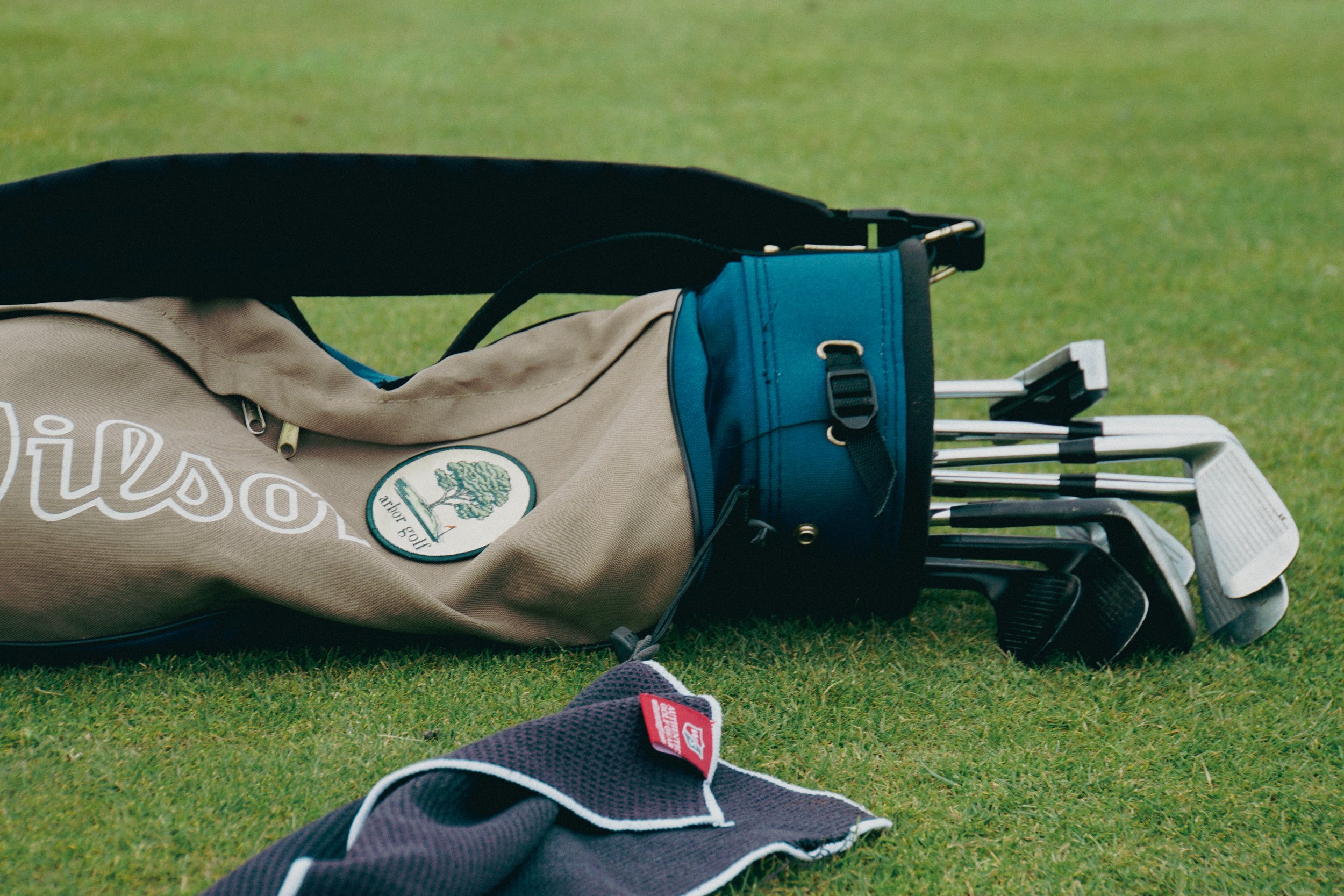 Golf bag with clubs and towel on grass