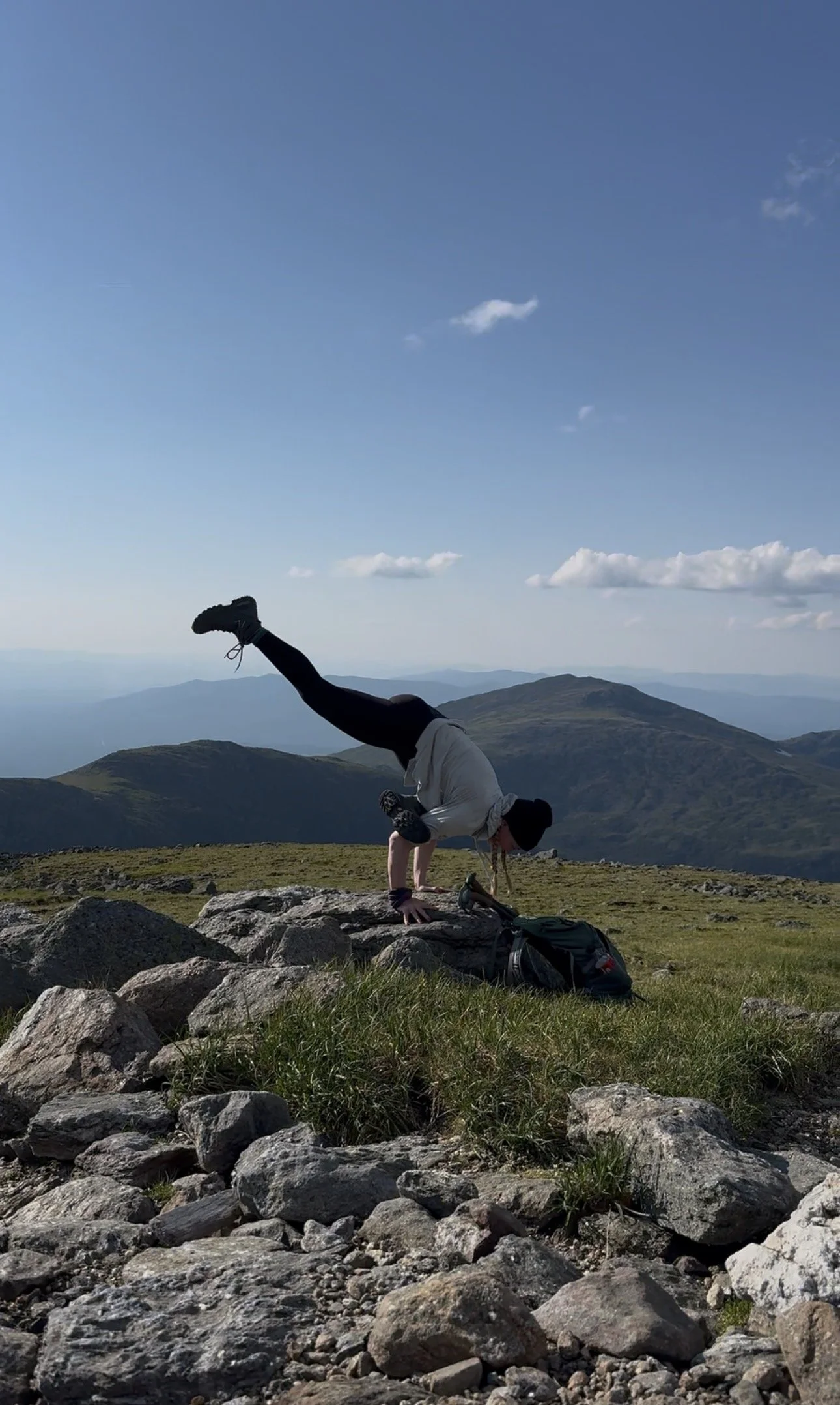 BK practicing an arm balance on the rocks near the Mount Washington summit during a BK:ONE retreat.