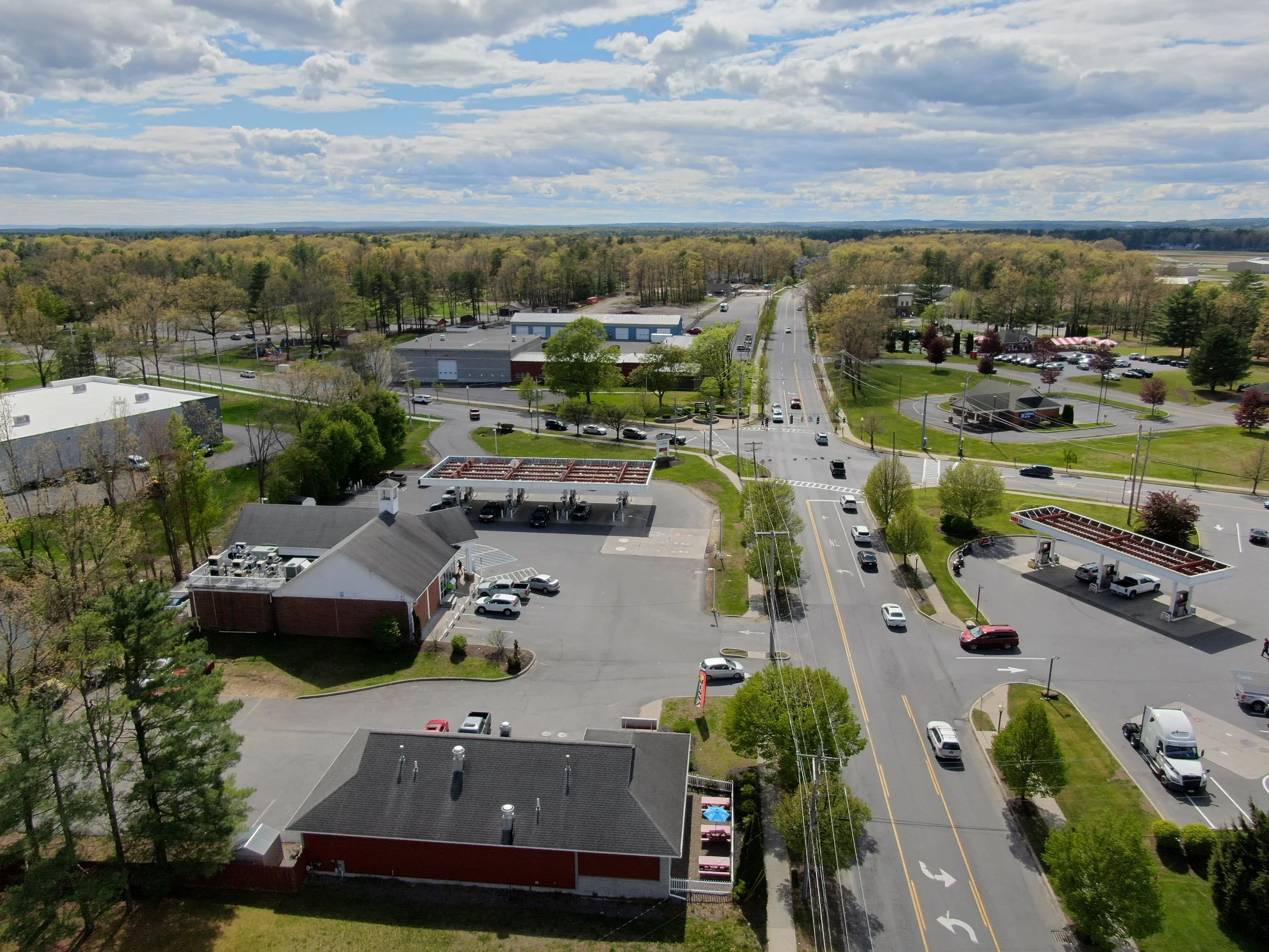 Aerial image showing the Milton Town Center intersection including roads with cars traveling on them and buildings and businesses located at the intersection.
