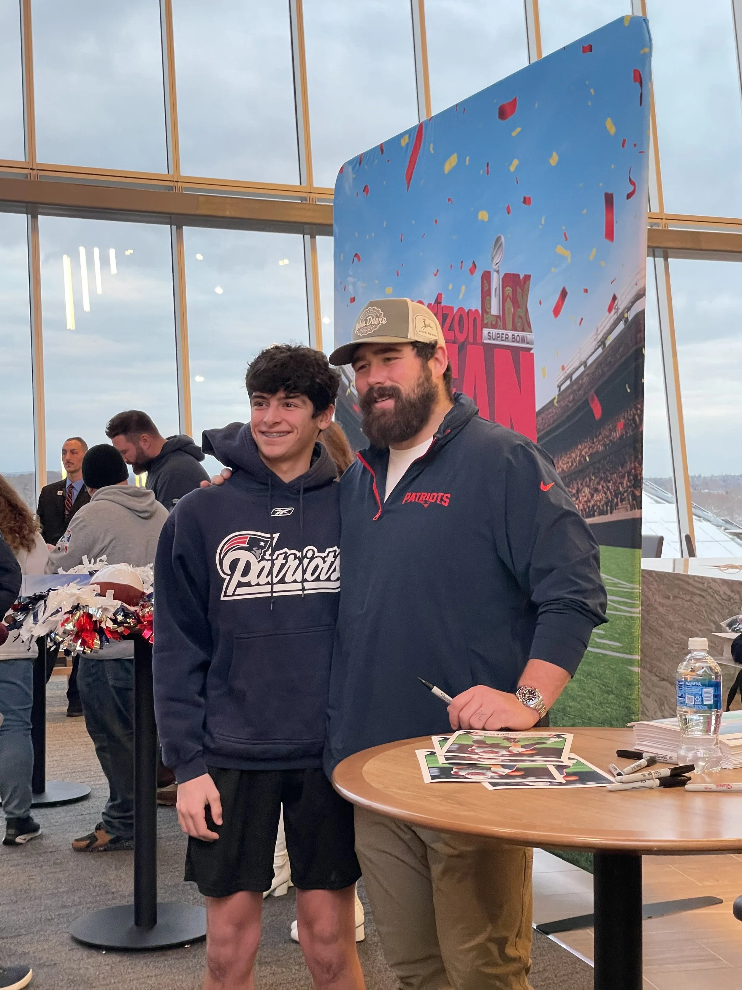 Patriots center David Andrews at a fan event for Verizon. Posing with a fan during a memorable moment.