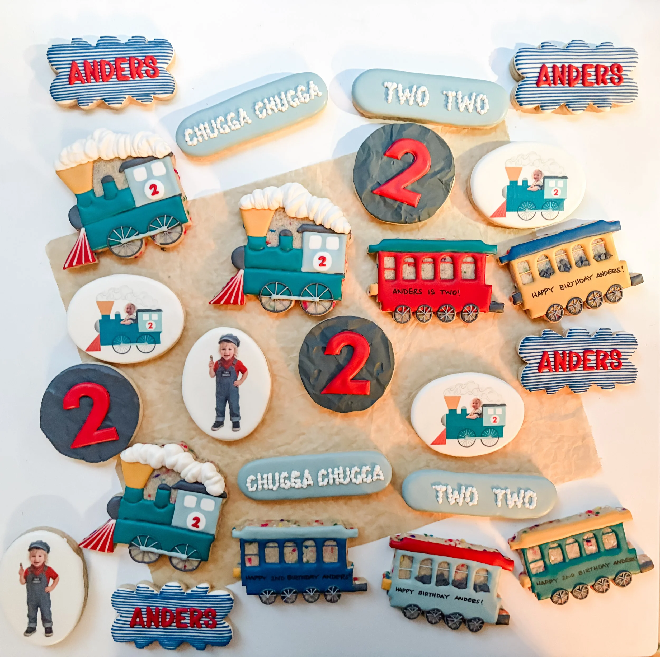 Decorative cookies celebrating a child's second birthday, including train-shaped cookies with the name 'Anders,' 
