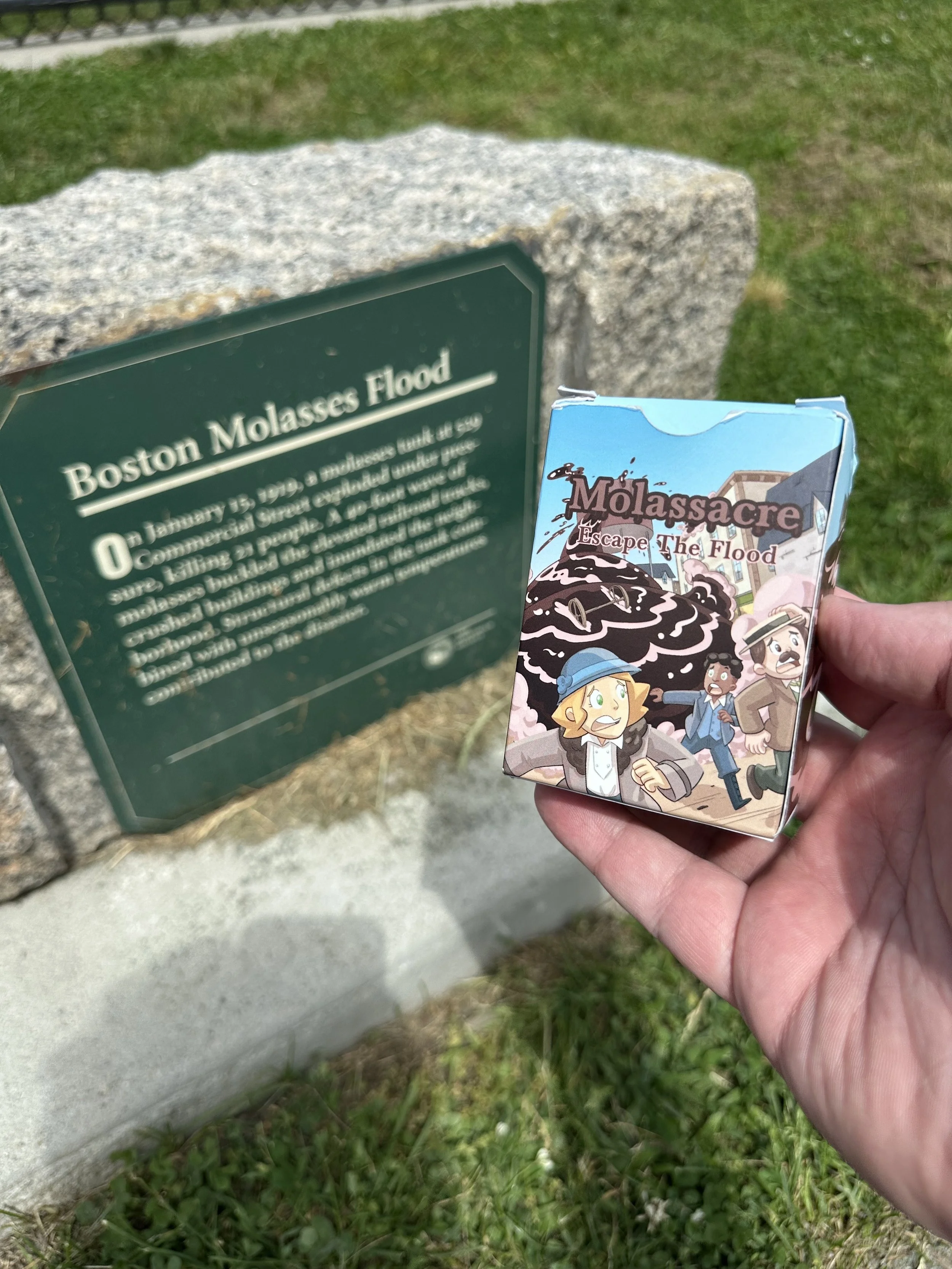 An image of the Molassacre Game in front of the Molasses Flood sign.