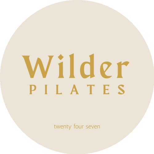 Wilder Pilates logo with the words "Wilder Pilates" in gold lettering and "twenty four seven" below on a beige background with a black curved design in the top left corner.