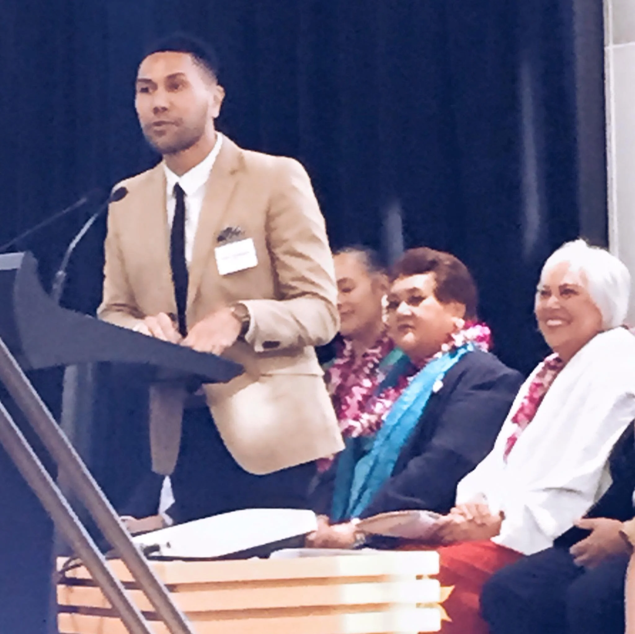 Andre Afamasaga at the Prime Ministers Pacific Youth Awards at NZ Parliament with Dame Winnie Laban in the background, with then Prime Minister John Key