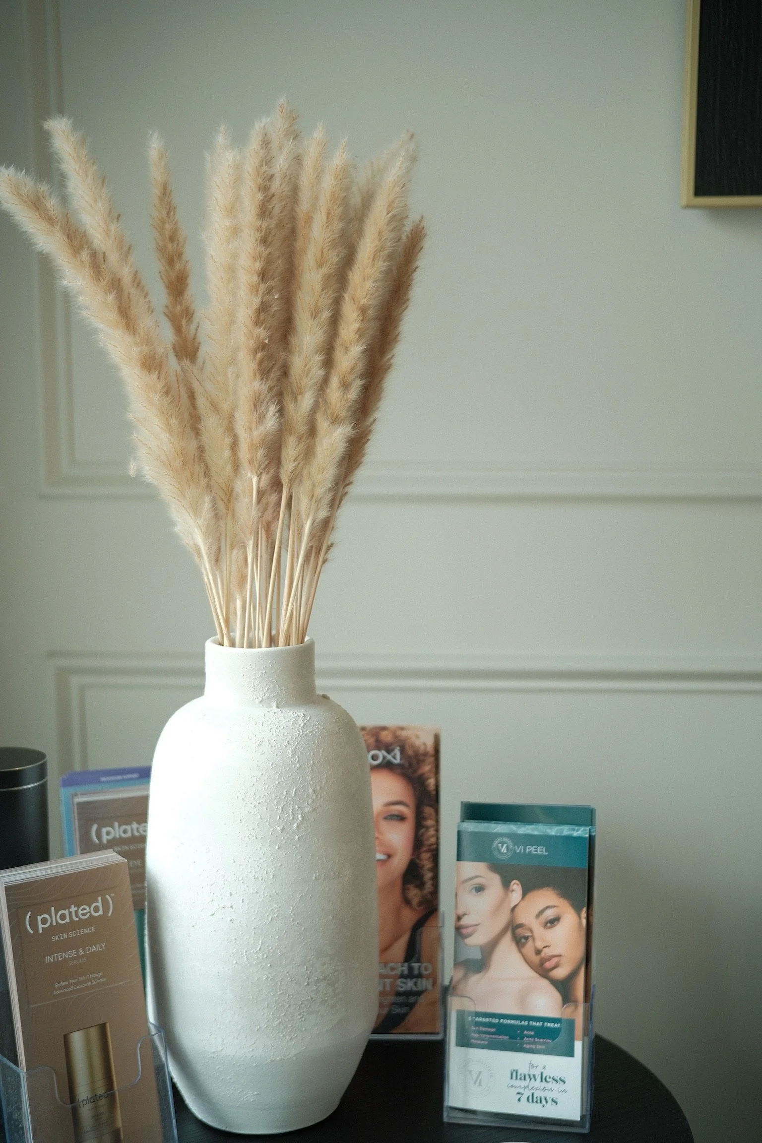 Black and white photo of a woman looking upward with closed eyes, wearing an off-shoulder top.