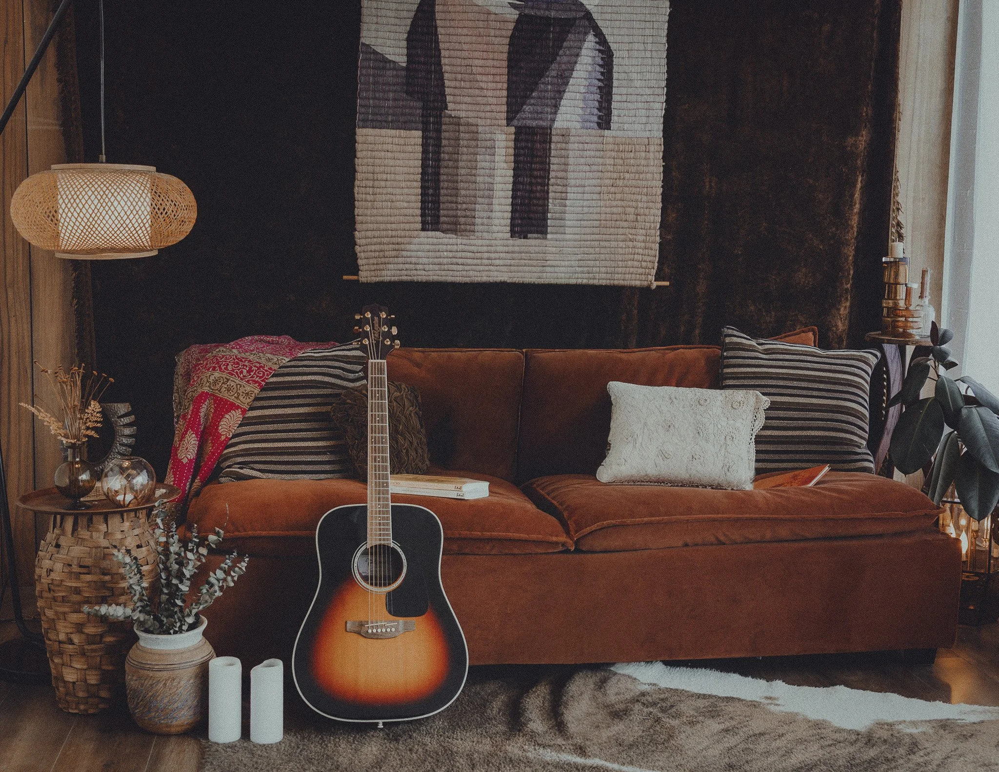 Music-inspired editorial portrait set featuring a leather sofa and acoustic guitar for Stripped Down Sessions at Love Street Pictures.