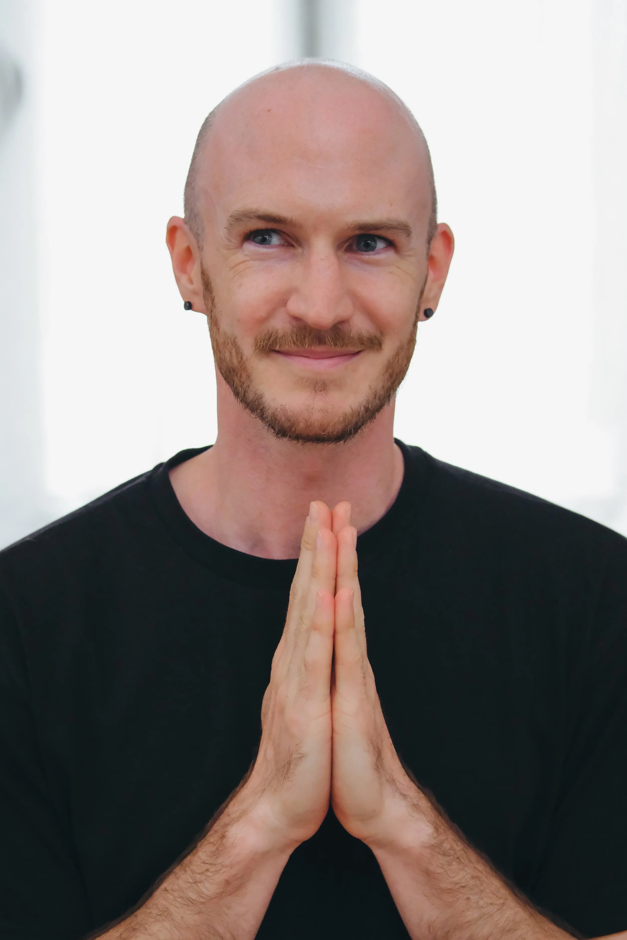 Gregor Eistert, smiling softly, with hands held near his chest.