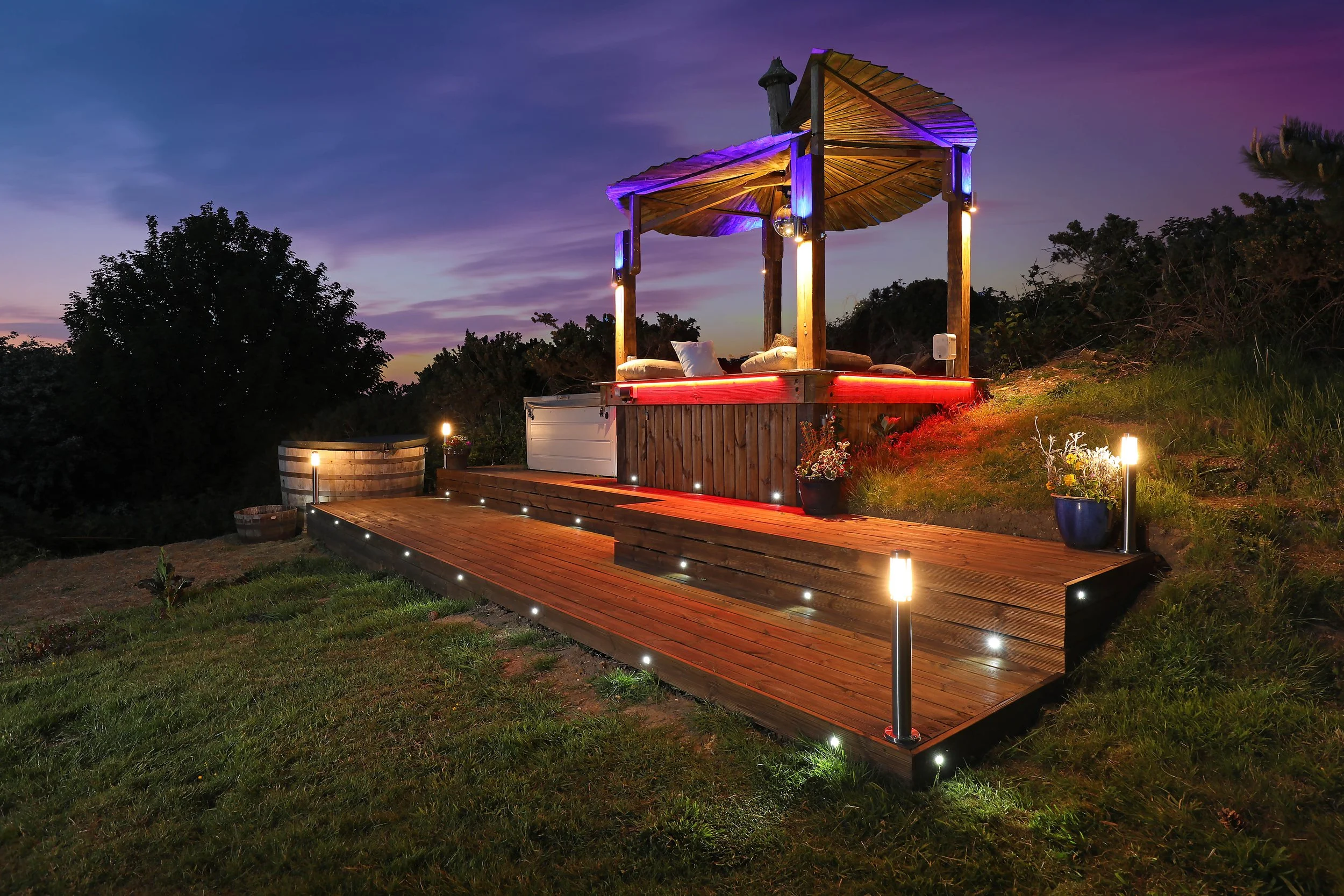 Luxurious gazebo with colorful lighting and surrounding greenery, perfect for relaxation at a retreat accommodation in the UK retreats