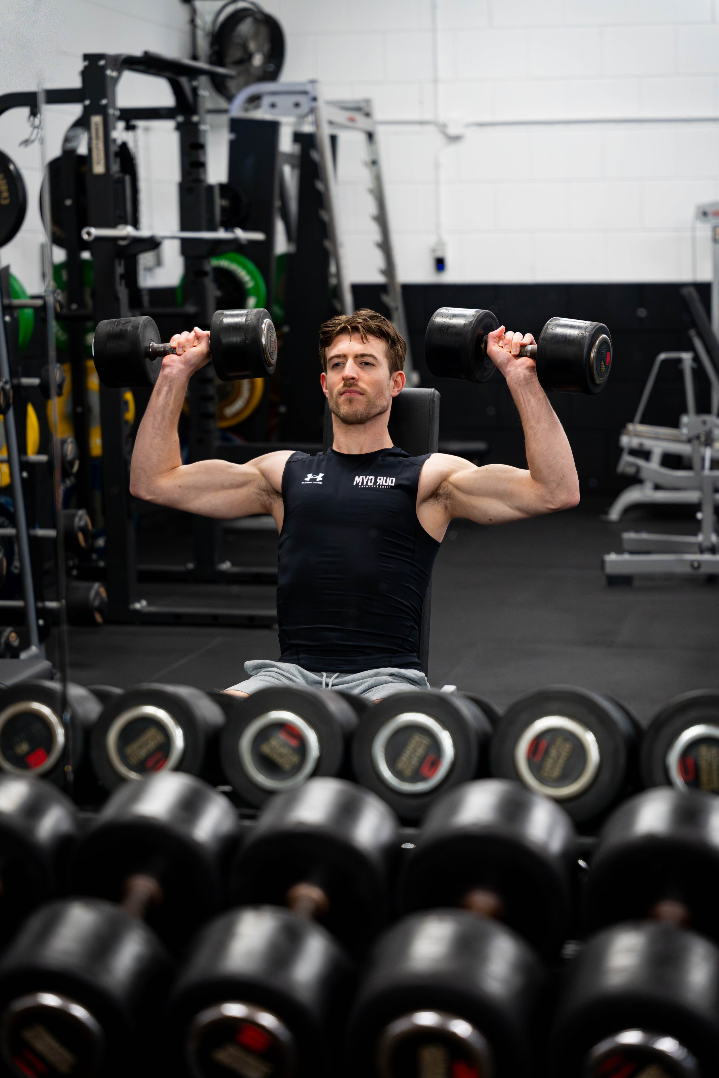 Man die traint met dumbbells in een sportschool