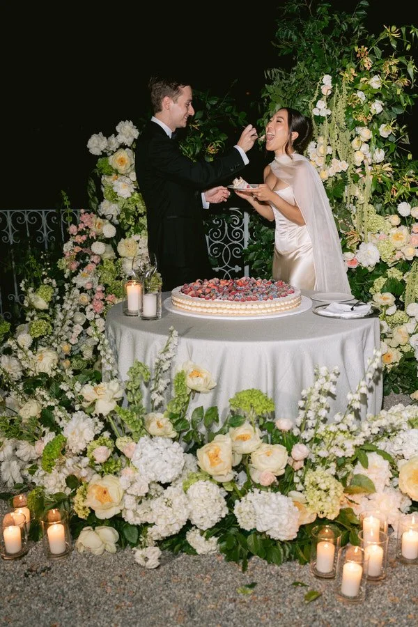 my-lake-como-wedding-planning-planner-expert-italy-bride-groom-married-couple-cutting-cake-together-white-peach-florals