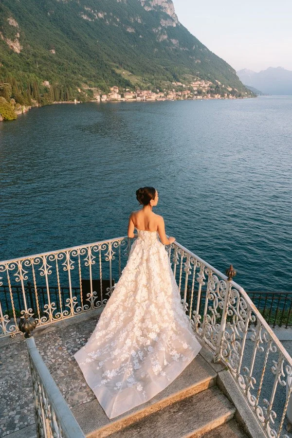 my-lake-como-wedding-planning-planner-expert-italy-bride-long-lace-dress-looking-out-lake-mountains-alone-romantic-beautiful