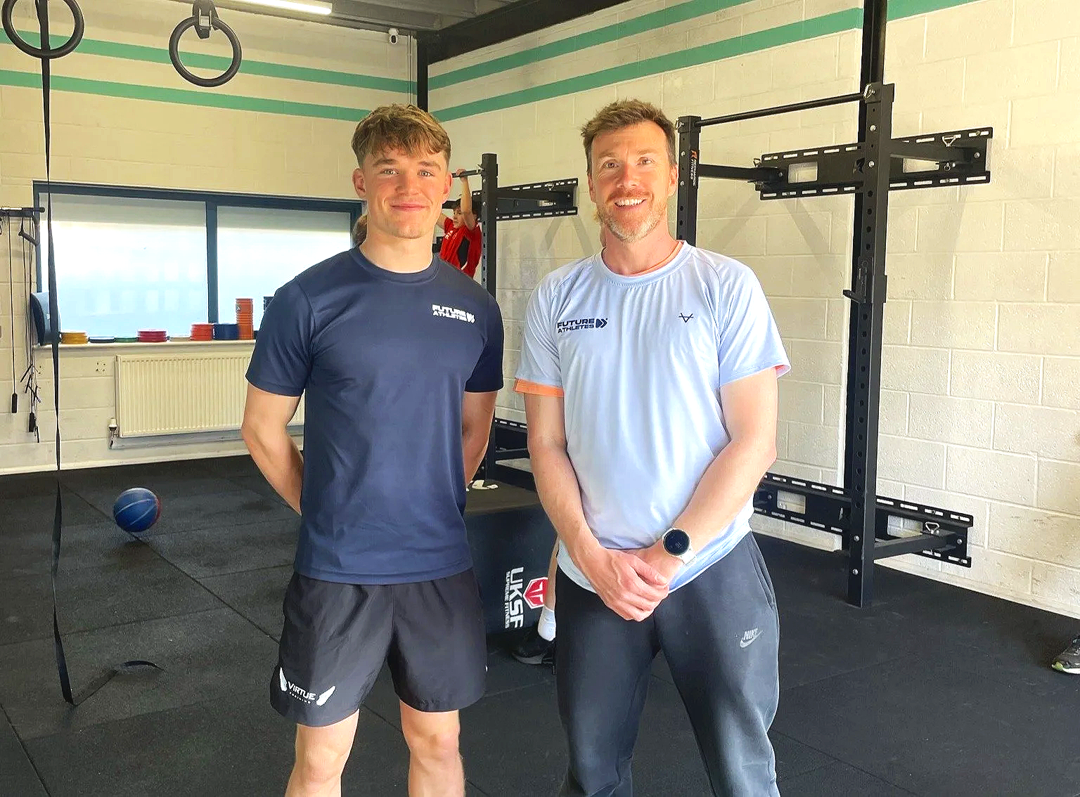 Coaches Adam and Felix smiling in a gym.