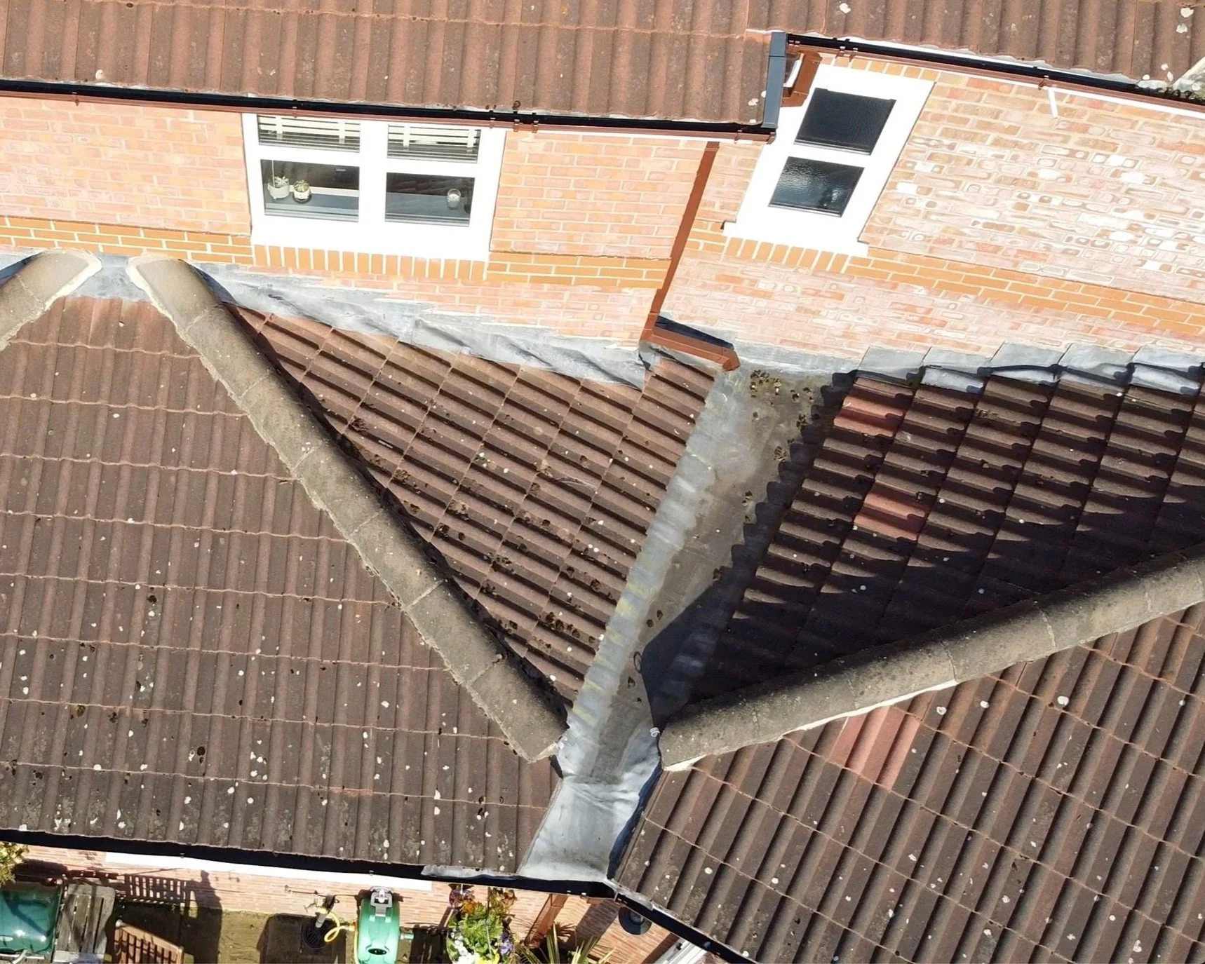 Aerial view of a tiled roof on a brick house.