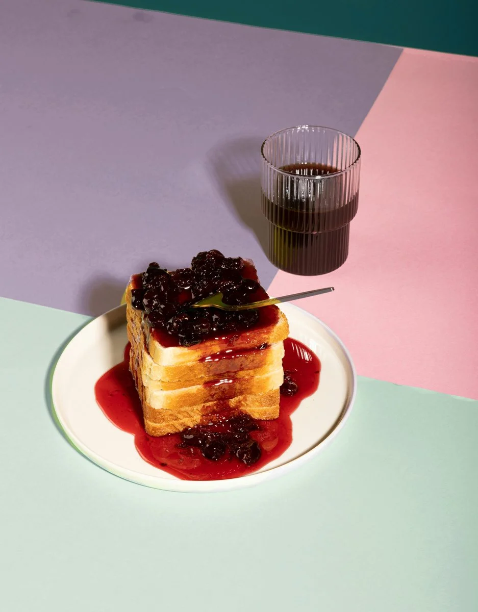 A delicious looking stack of french toast smothered with blackberry topping