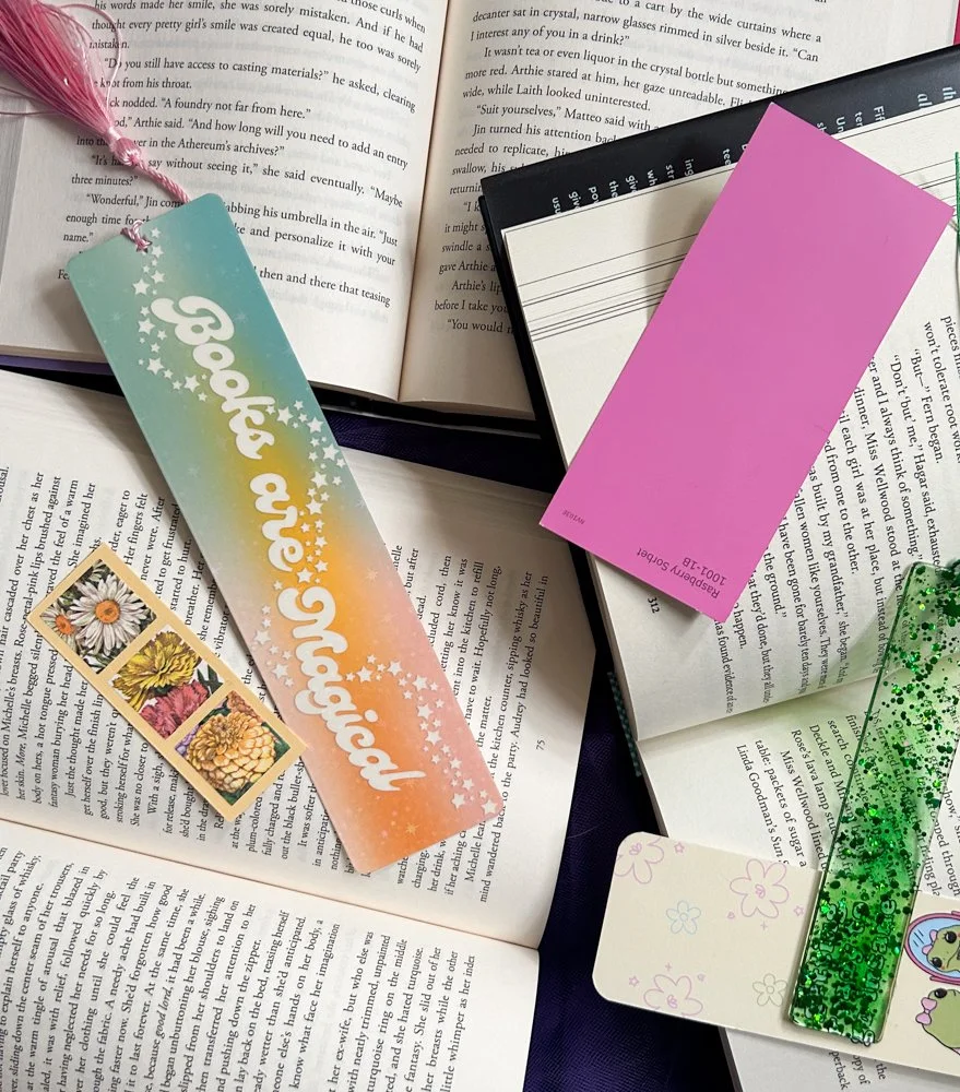overhead shot of three open books with colorful bookmarks scattered on top