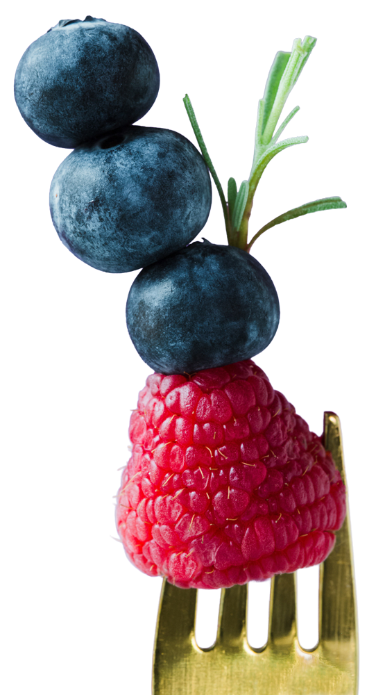 cut out of a raspberry and three blueberries speared on a fork