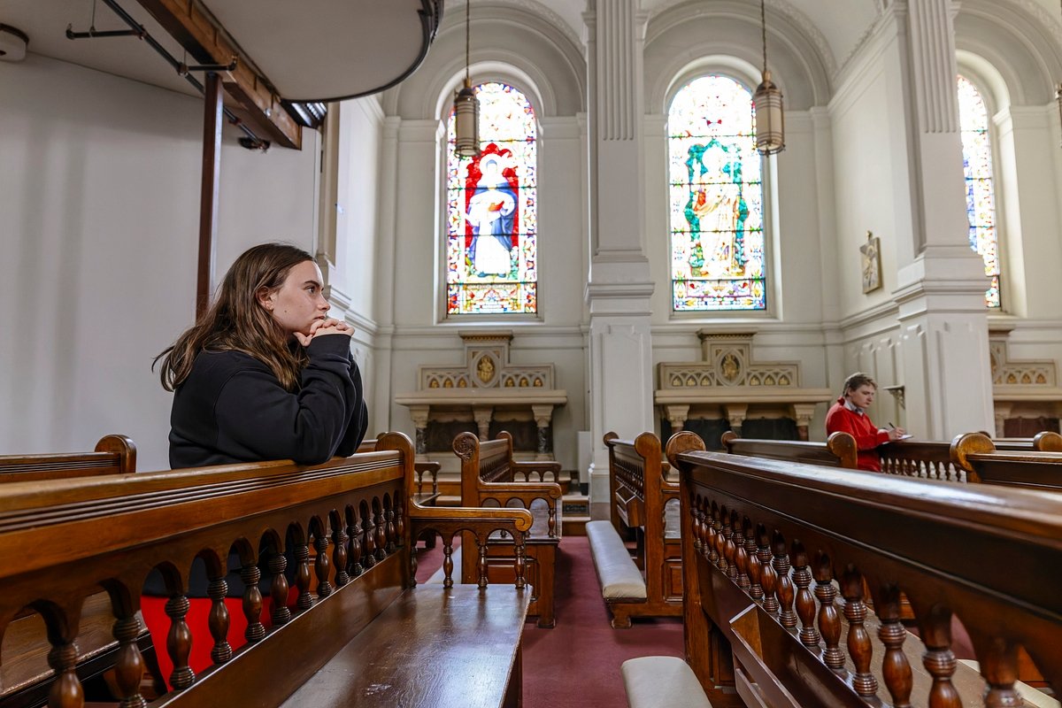 student praying in chapel