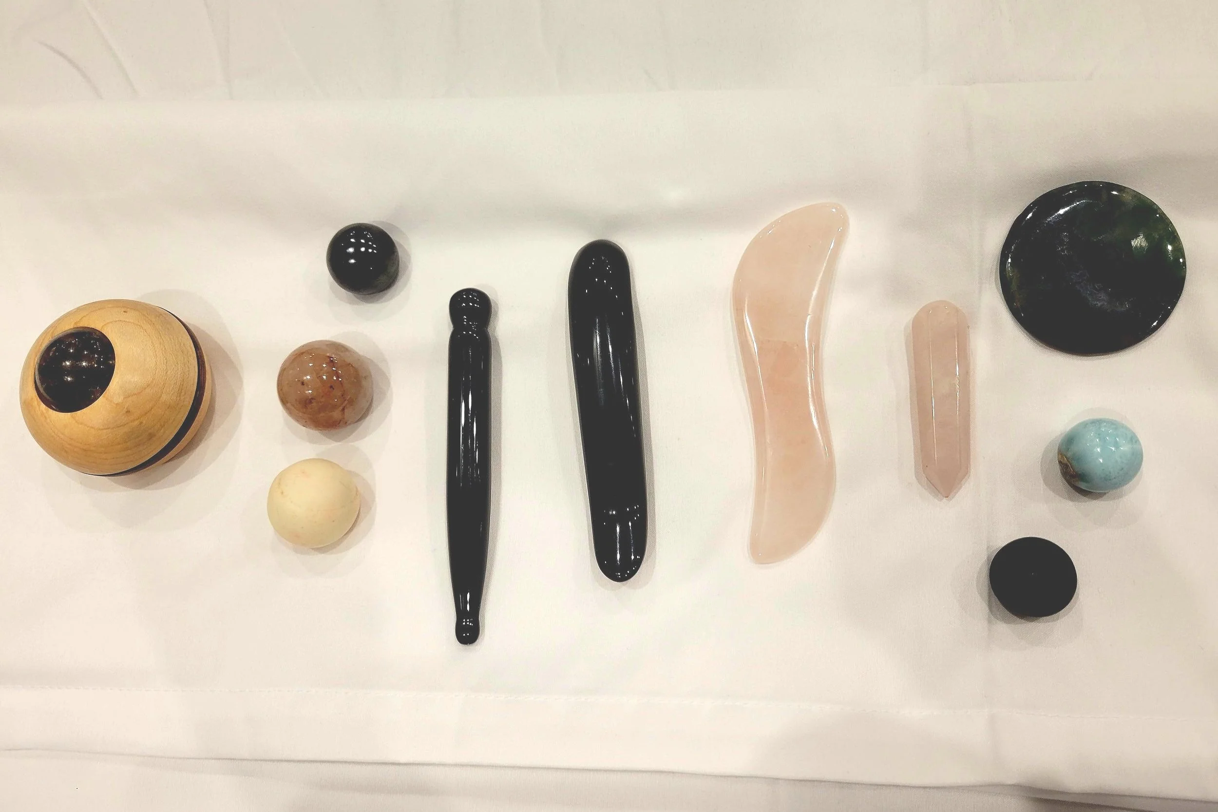Collection of various stones and minerals arranged in a row on a white surface.