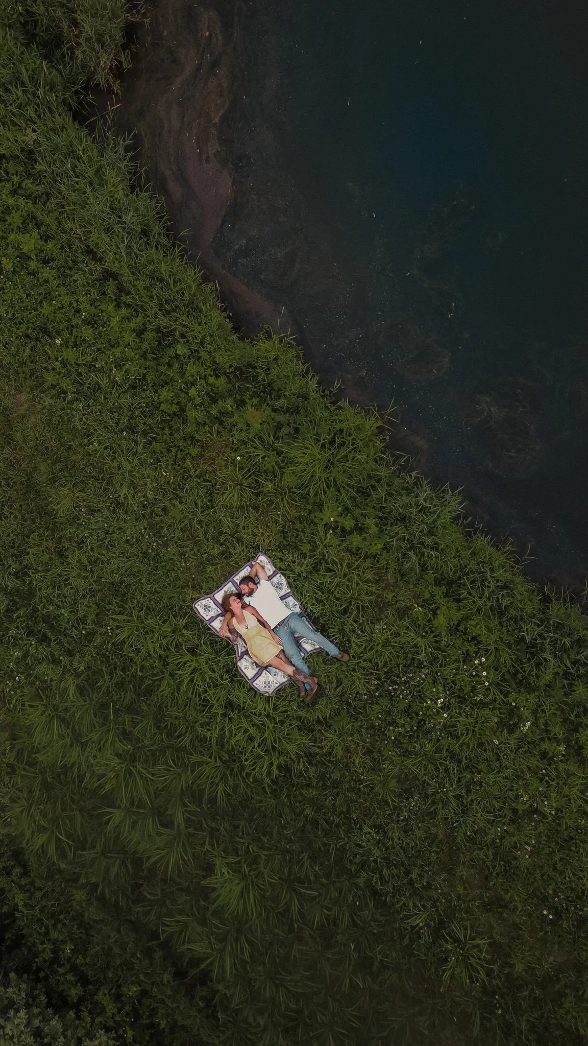 drone photo of couple laying in field