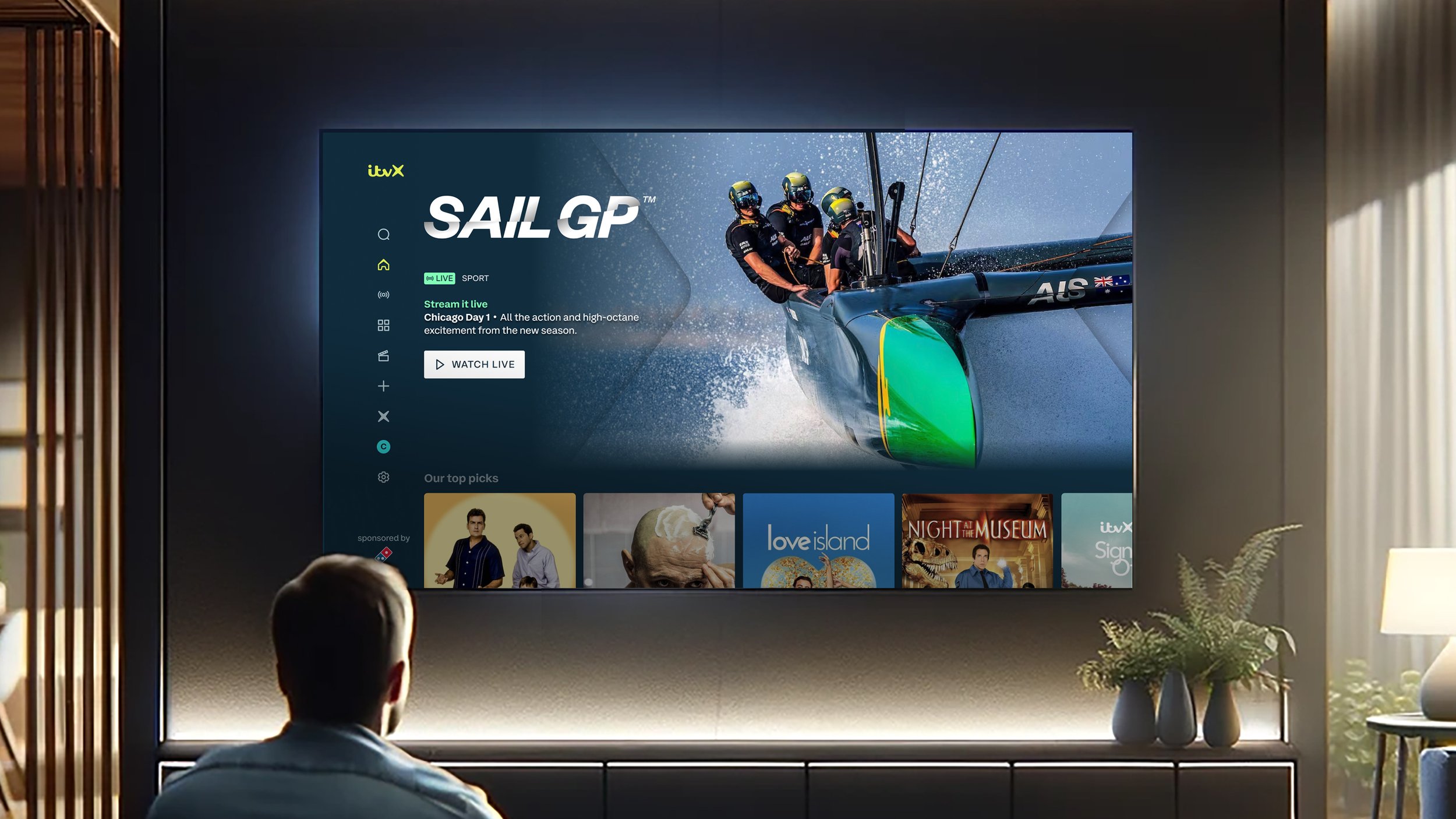 Man watching TV displaying SailGP in the hero of the ITVX app