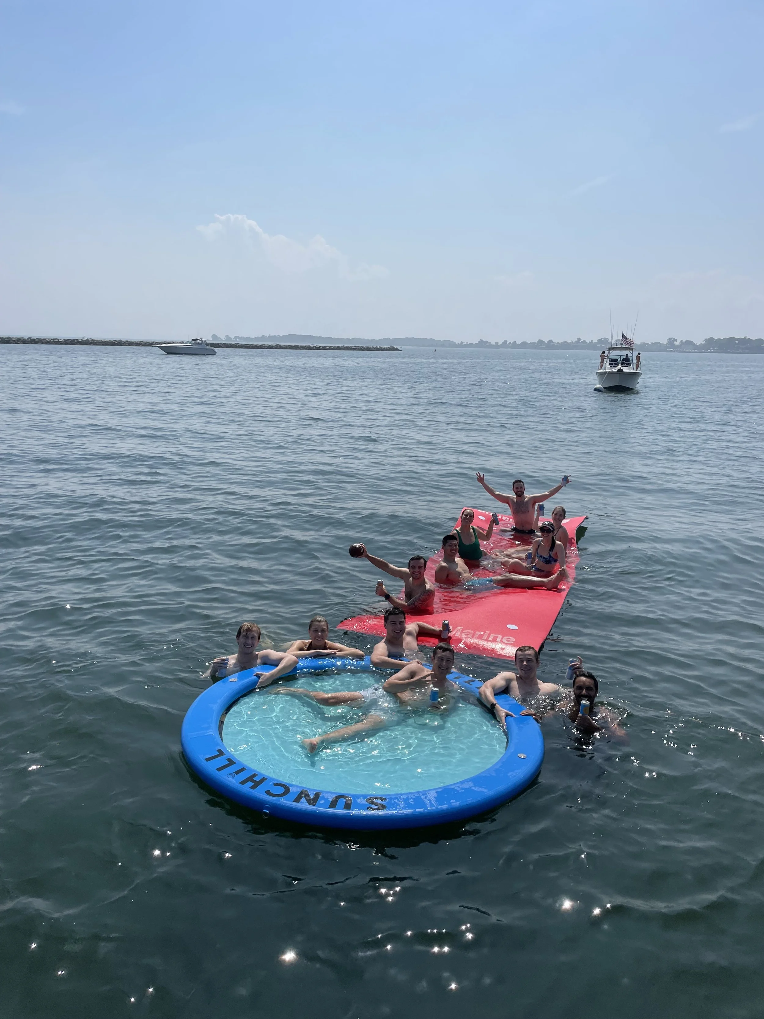 Guests swimming while on a private boat charter in Stamford, CT with Fairfield County Boat Charters