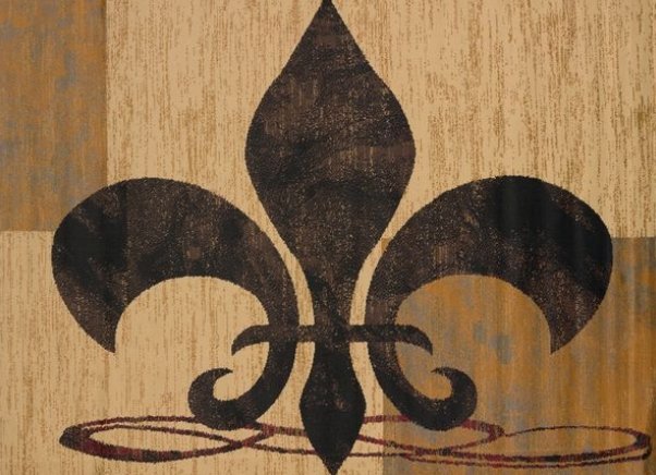 Close-up of a black fleur-de-lis symbol painted on a wooden surface.