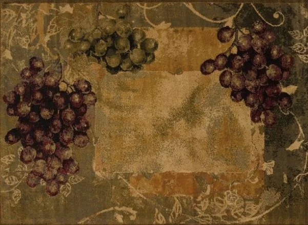 A vintage-style tablecloth featuring clusters of red and green grapes, with a worn-out central rectangular area.